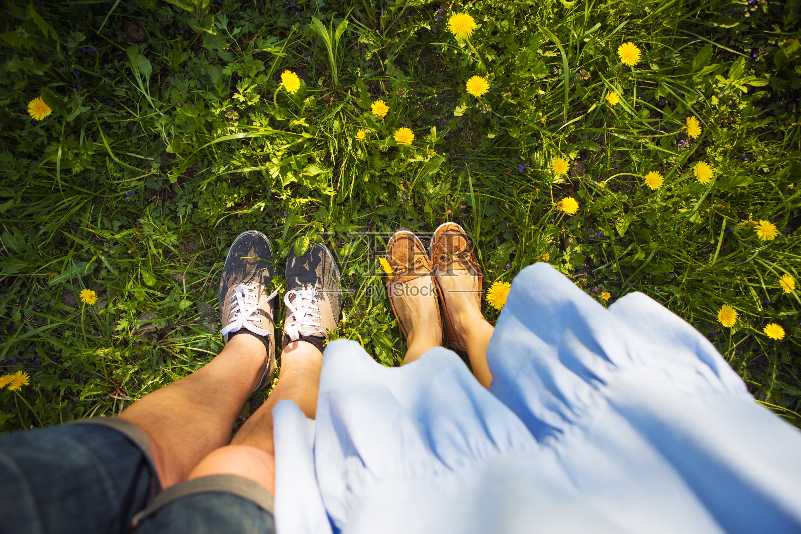 18、女人的腿踩在绿草地和黄花上，空格为文字空格照片摄影图片