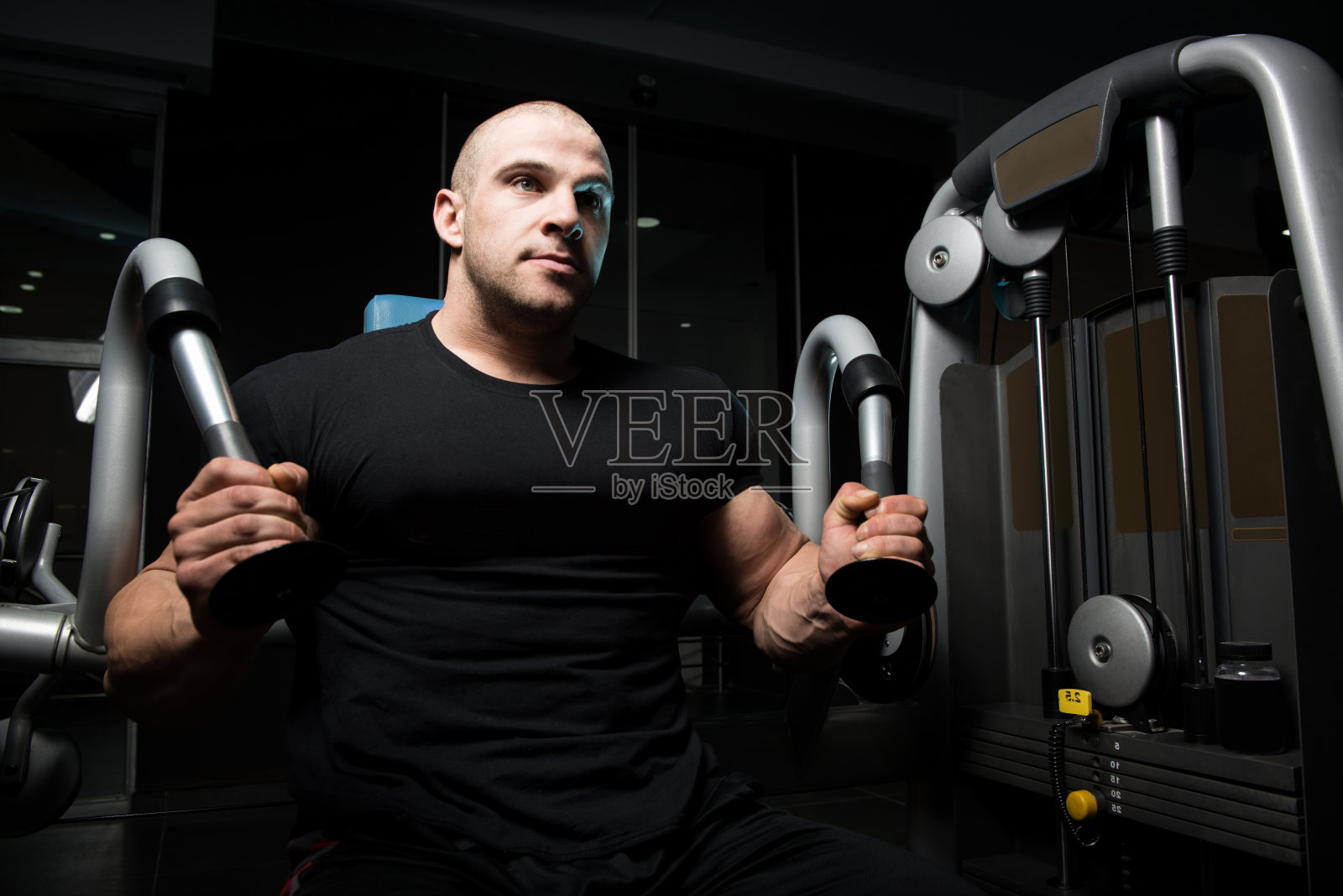 健美运动员用电缆做三头肌的剧烈运动照片摄影图片