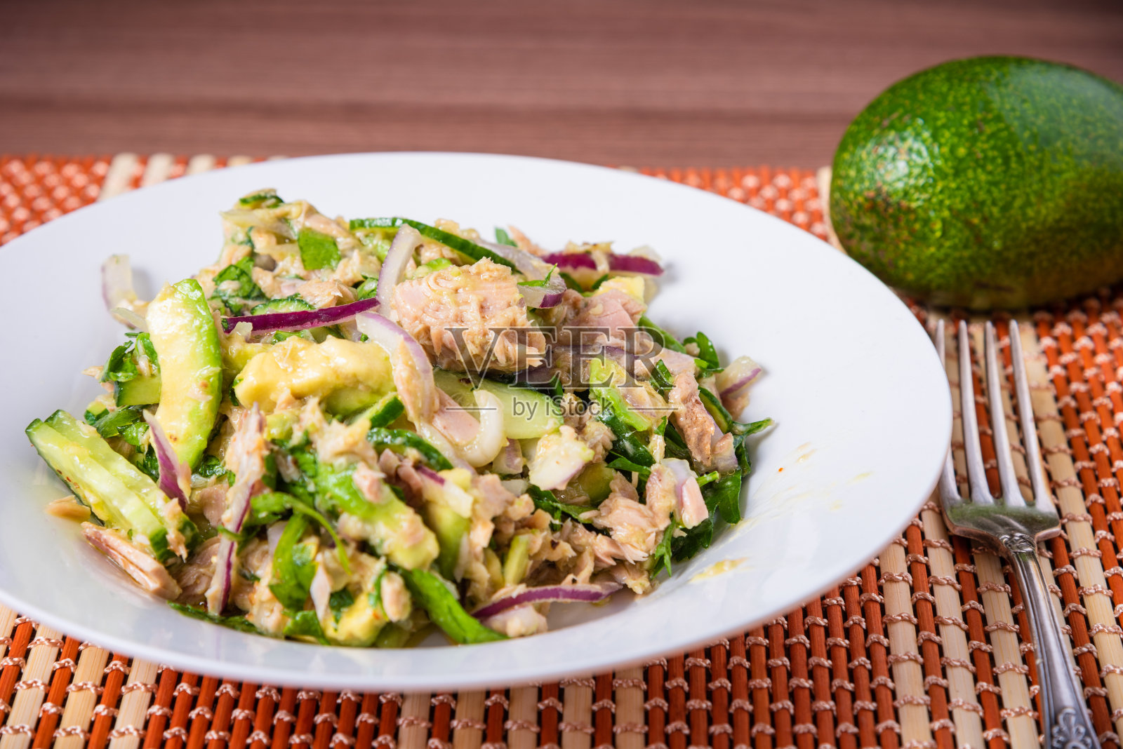 美味的牛油果沙拉和金枪鱼罐头洋葱盘，特写照片摄影图片