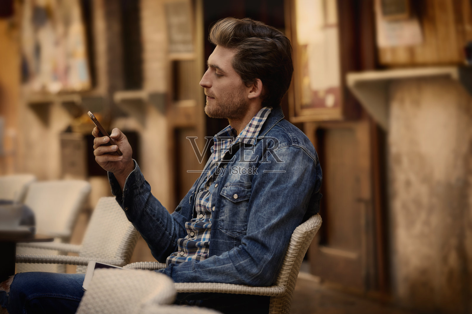 一名年轻人在户外咖啡馆里拿着智能手机照片摄影图片