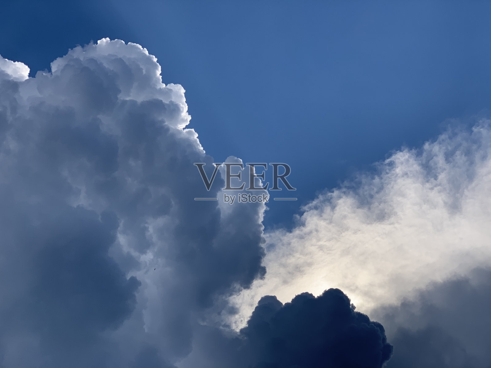 暴风雨的云在阳光的天空中。照片摄影图片