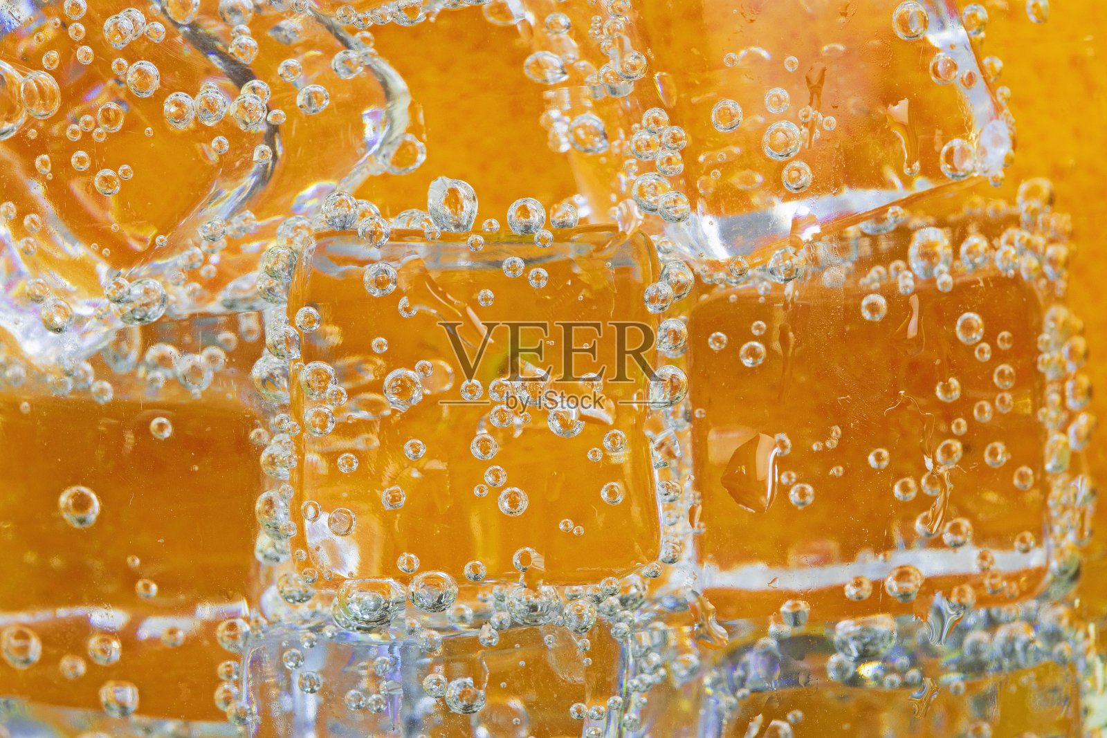 冰加气泡碳酸饮料-橘色背景。照片摄影图片