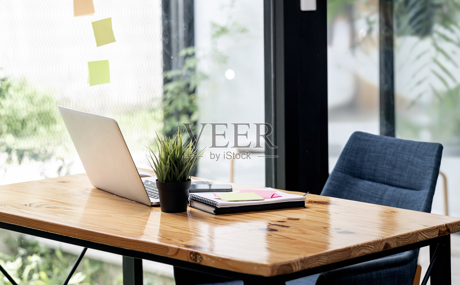 舒适的家庭办公室，木桌上放着笔记本电脑。照片摄影图片