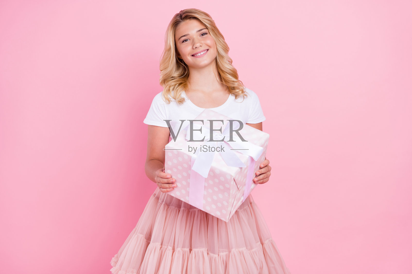 照片的年轻女孩快乐积极的微笑举行礼物盒生日派对孤立在柔和的颜色背景照片摄影图片