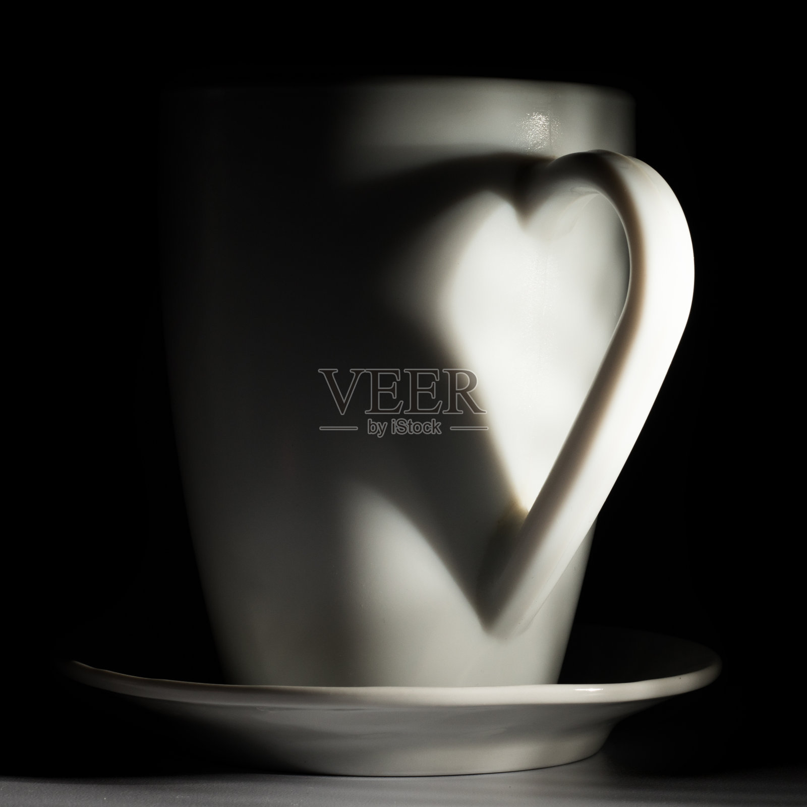 杯子的把手上投射出一个心形的影子照片摄影图片