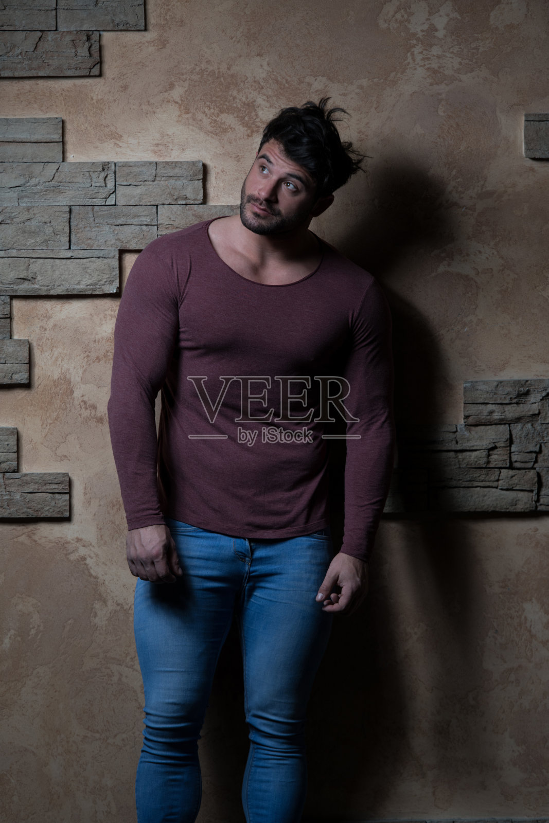 男人靠砖墙站着照片摄影图片