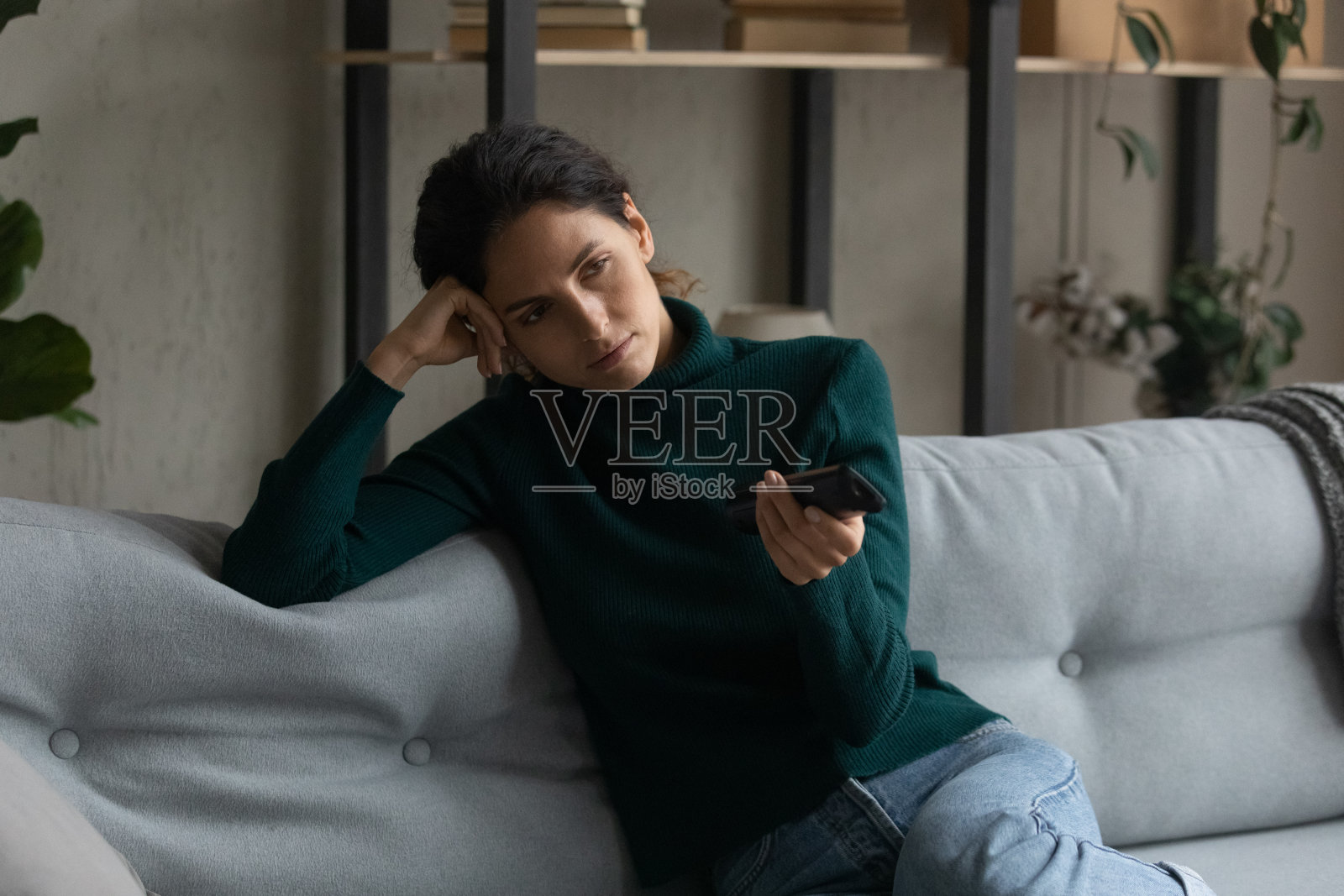 拿着电视遥控器换台的无聊女人特写照片摄影图片