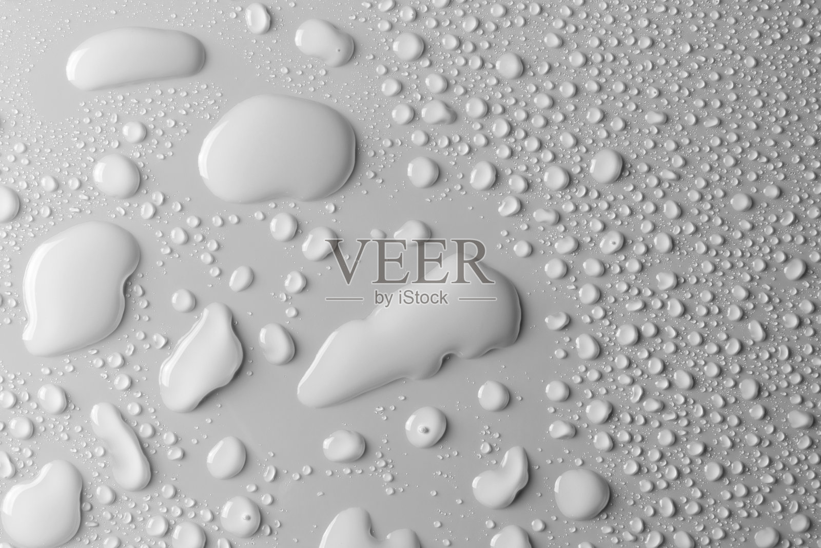 水滴在光滑的表面，灰色的背景照片摄影图片