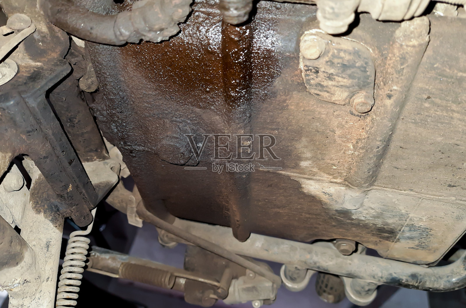 摩托车发动机在混凝土地板上漏油或脱落，发动机漏油特写照片摄影图片