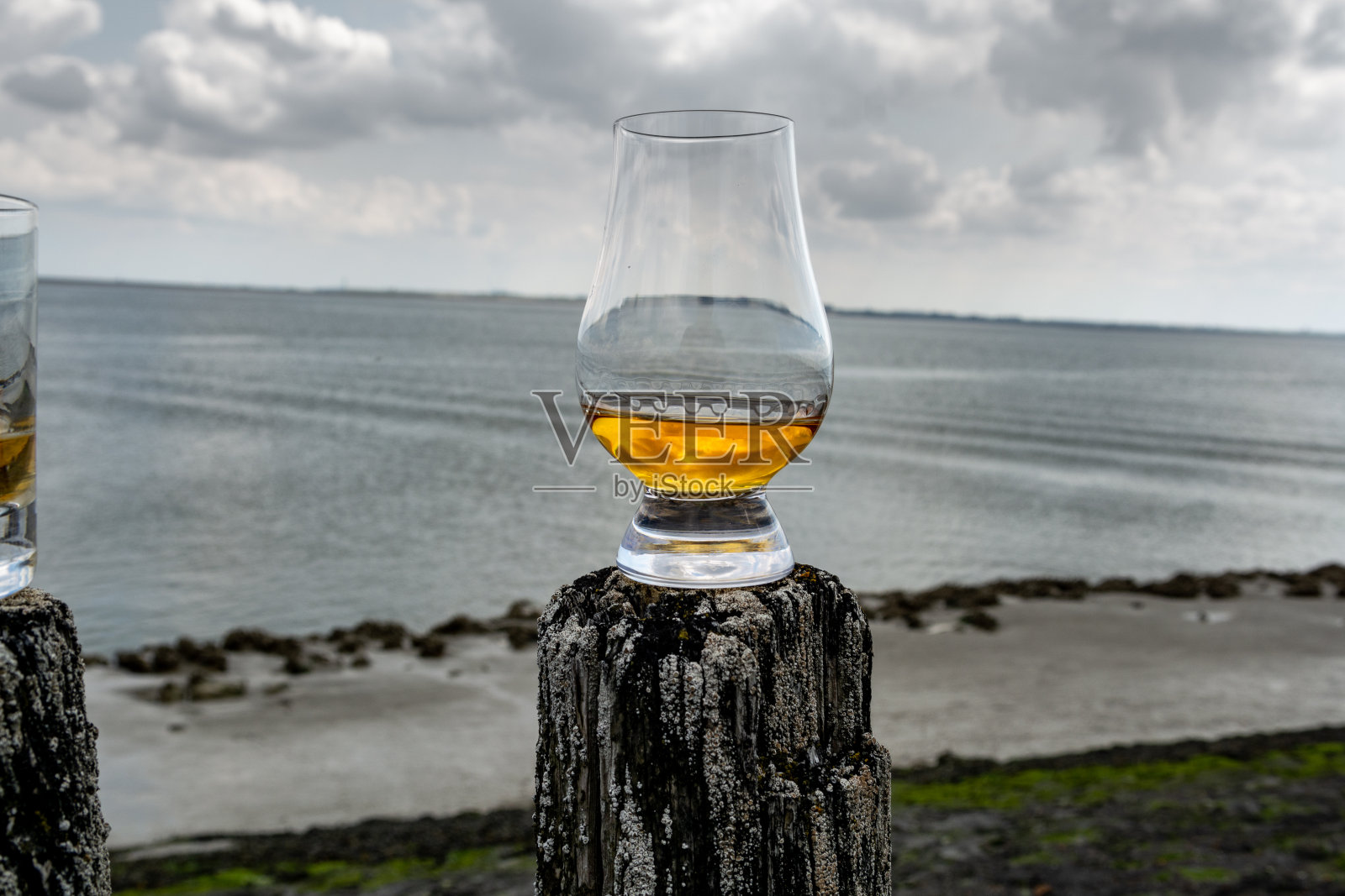 在苏格兰的海滨品尝威士忌，用古老的木杆和威士忌酒杯照片摄影图片