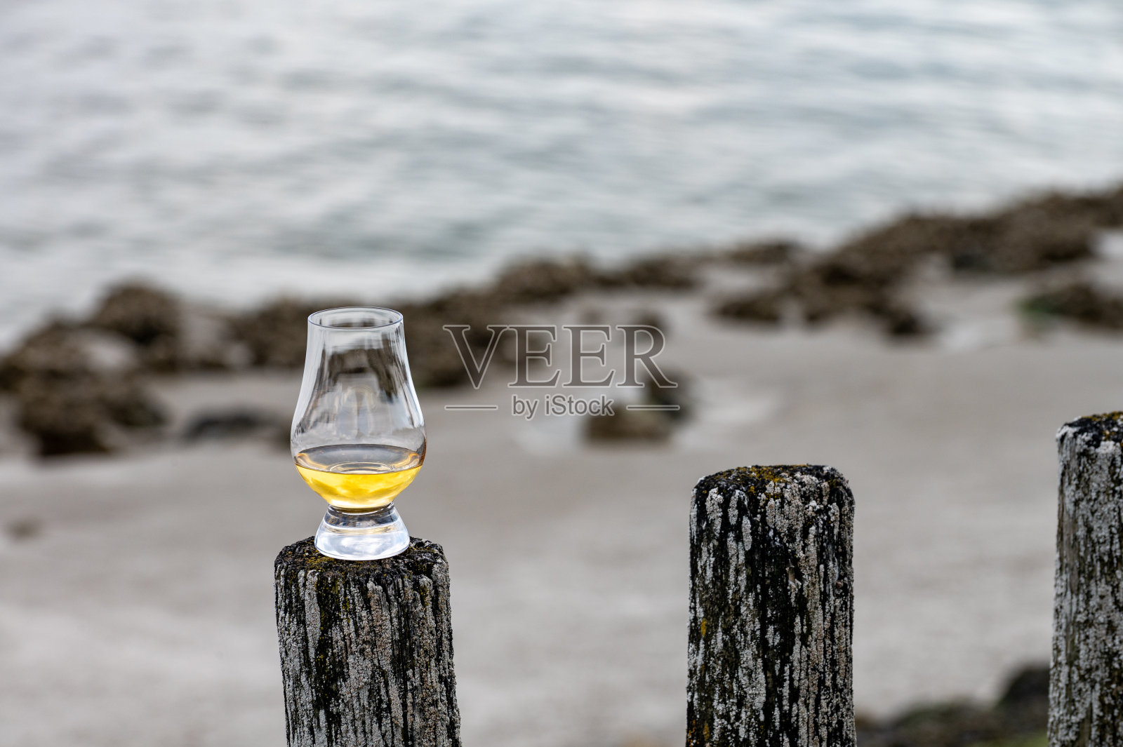 在苏格兰的海滨品尝威士忌，用古老的木杆和威士忌酒杯照片摄影图片