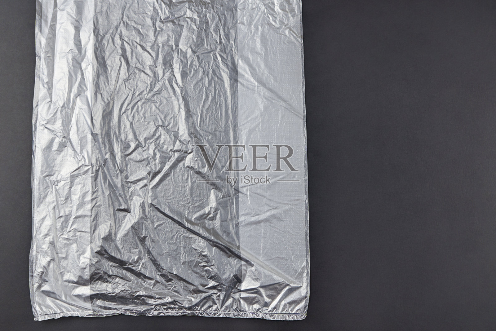 黑色背景上的塑料袋，环保污染概念。照片摄影图片