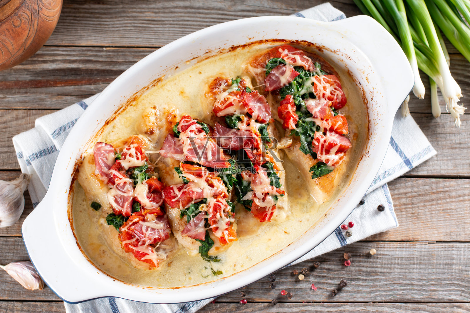 木桌上的烤盘里放着奶油蒜蓉调味的鸡胸肉。健康的减肥食品。俯视图，平躺照片摄影图片