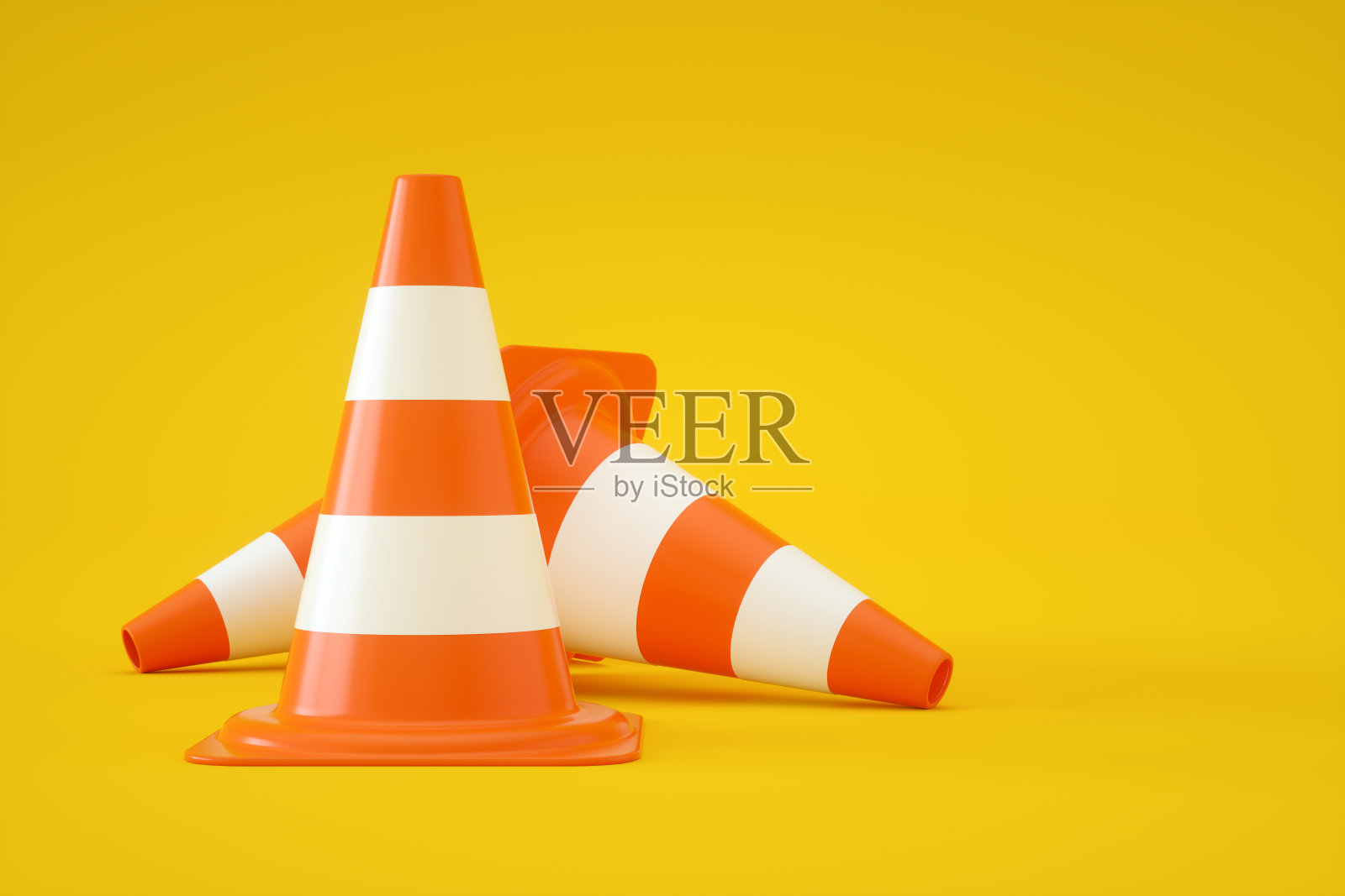 黄色背景上的交通锥照片摄影图片