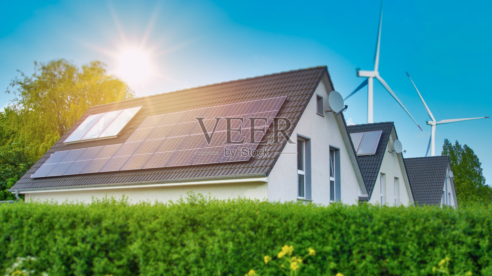 屋顶上的太阳能电池板和周围的风力涡轮机照片摄影图片