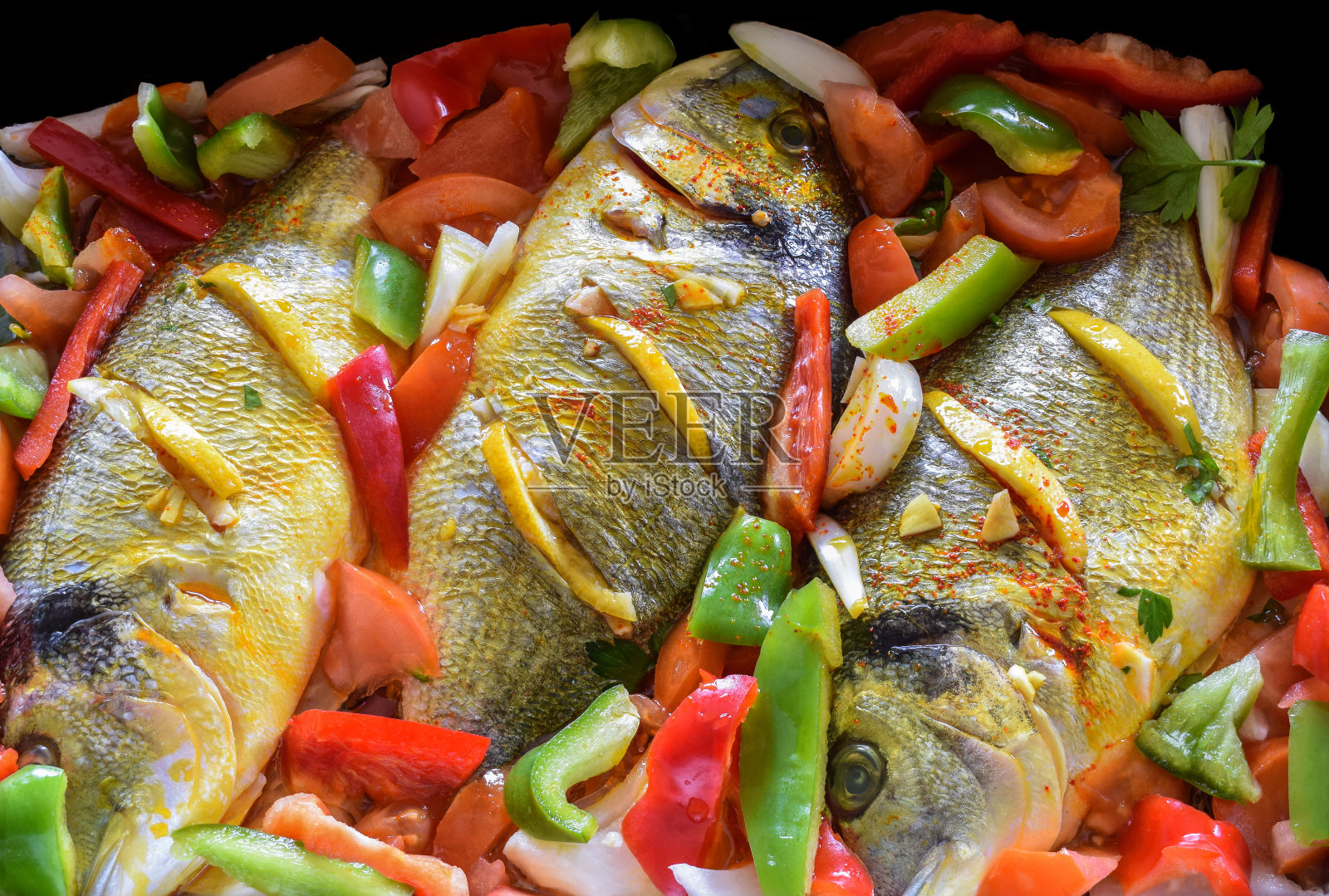 美味的金头鲤配柠檬，番茄和大蒜，准备烤照片摄影图片