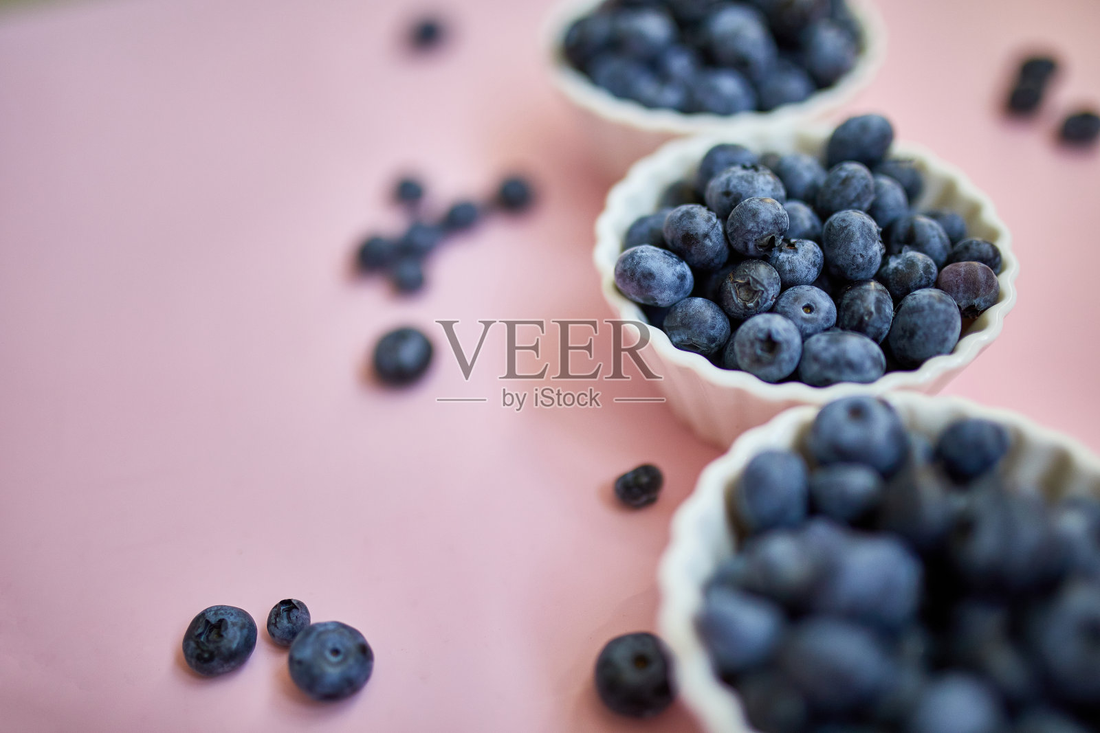 粉红色背景的碗里放着新鲜多汁的蓝莓照片摄影图片