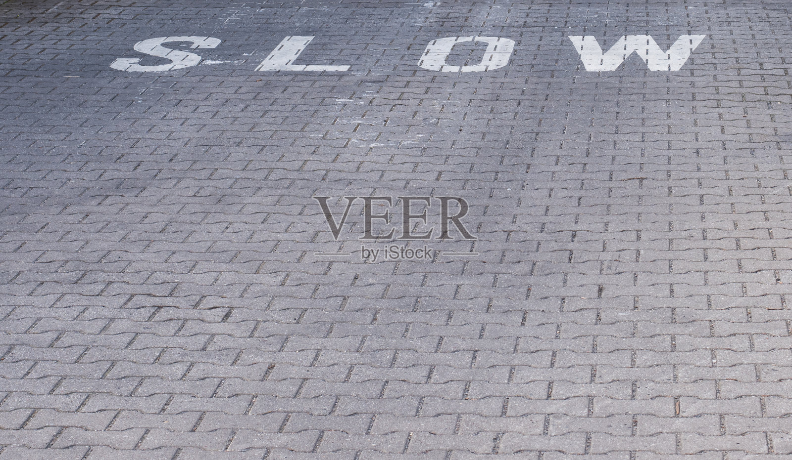 缓慢警告文字在人行道上。照片摄影图片