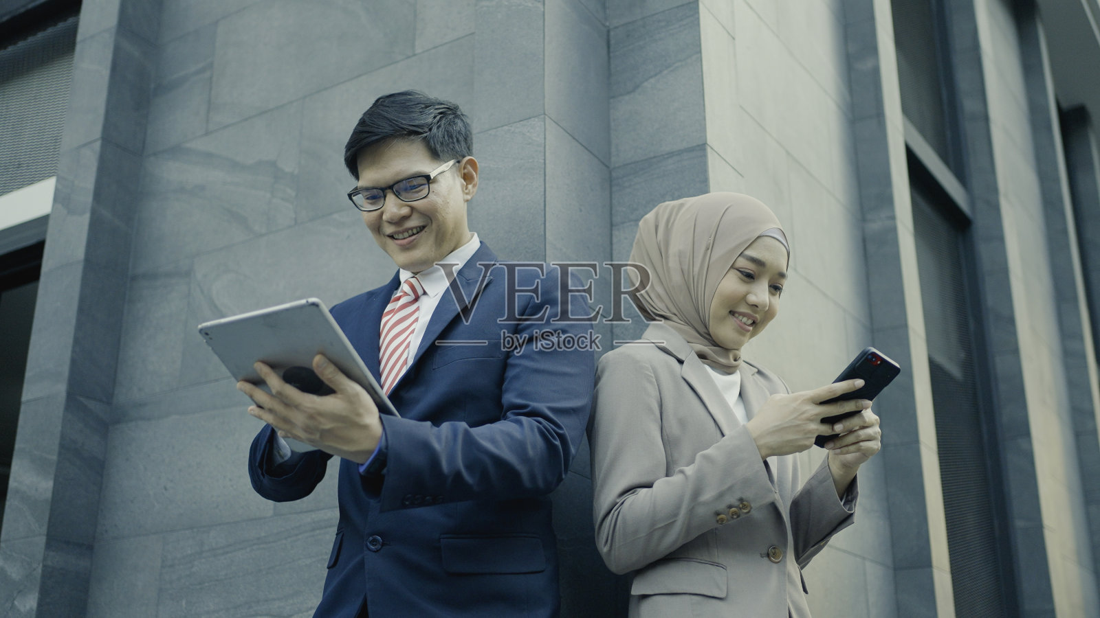 商人和女商人使用数字平板电脑和手机照片摄影图片