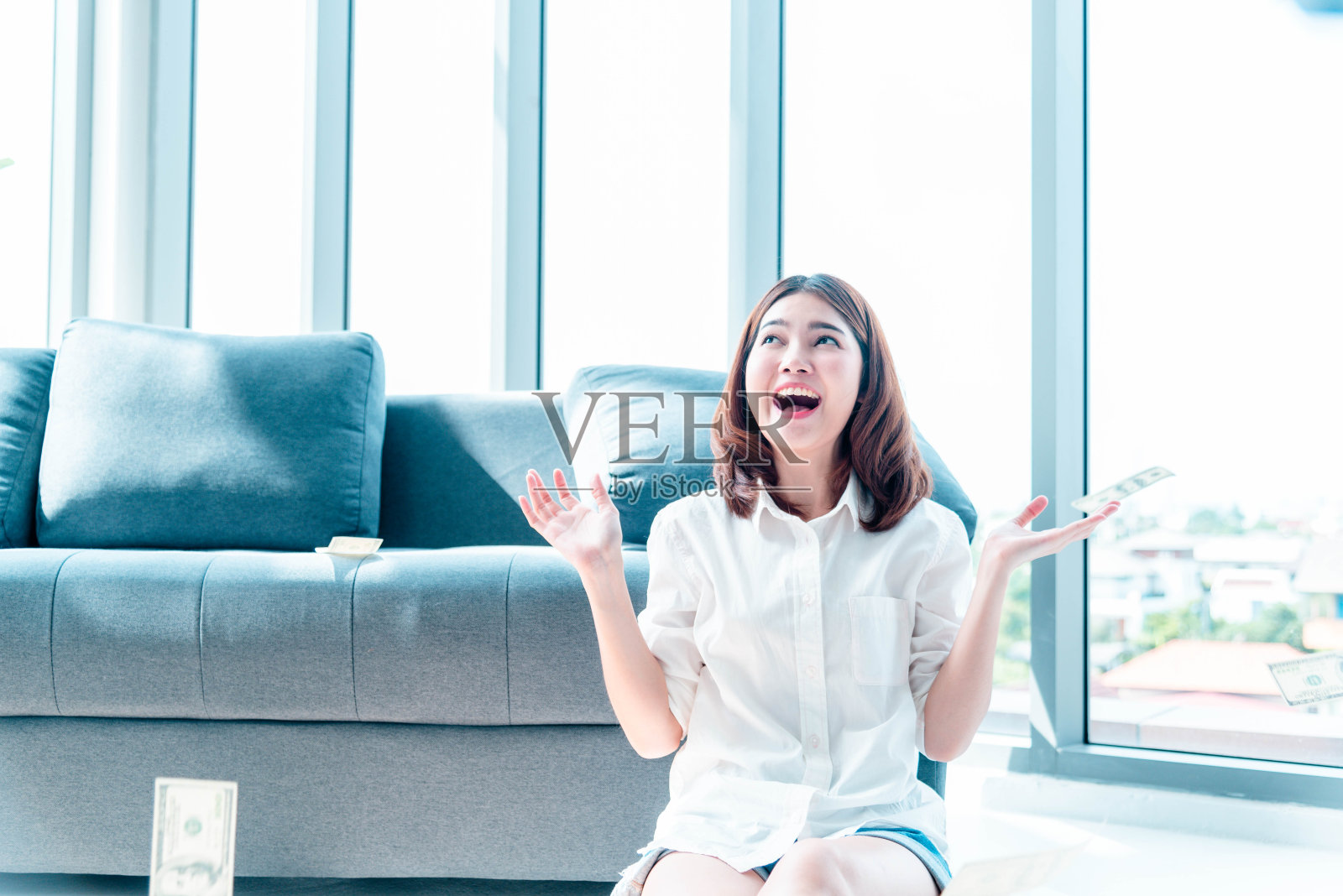 快乐年轻的亚洲女人拿着美元钱，扔在空中庆祝幸福舞蹈财富彩票钱雨点。胜利者成功的商人女人扔现金流快乐的钱笑脸照片摄影图片