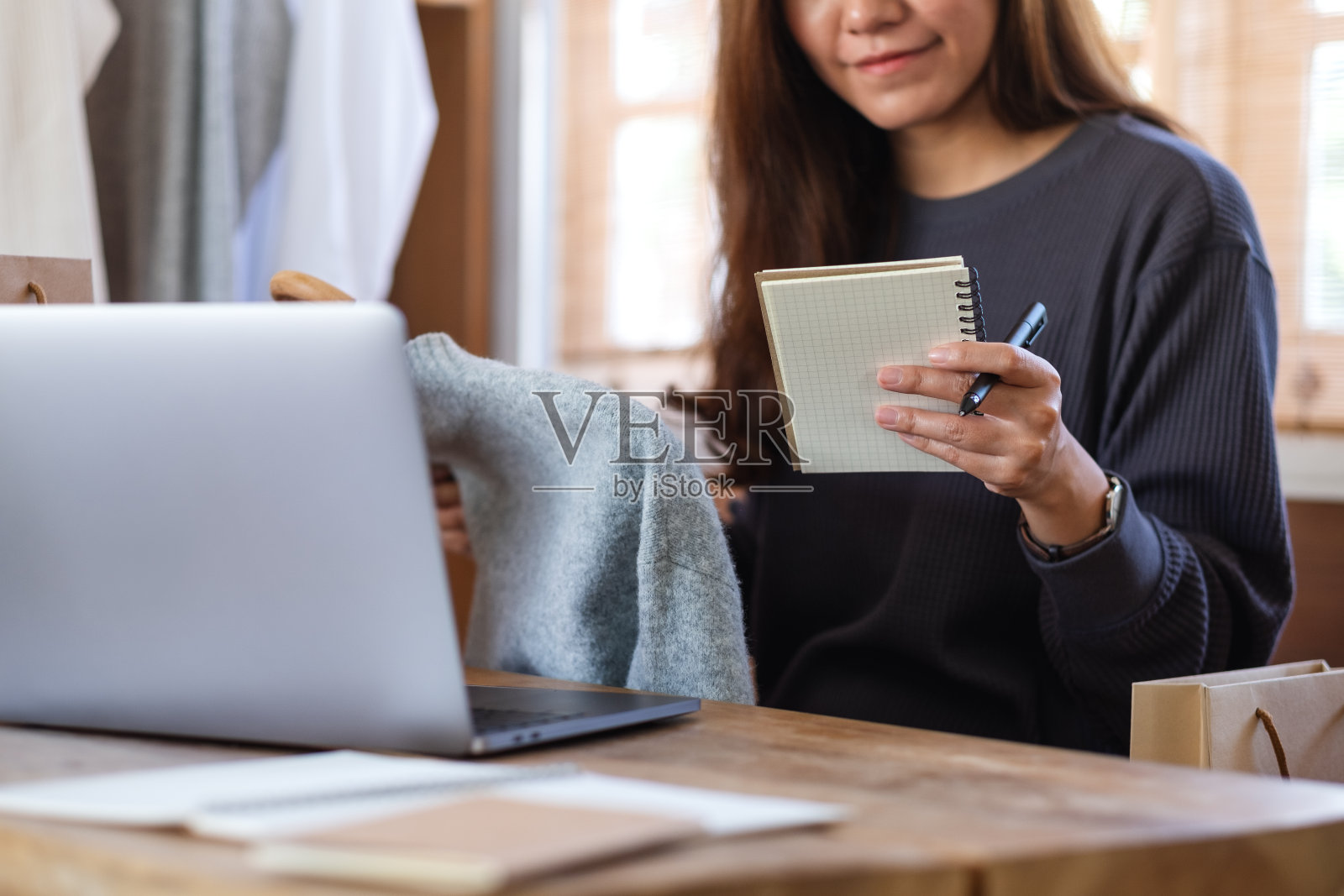 一名女企业家出售衣服，并检查客户订单的网上购物概念照片摄影图片