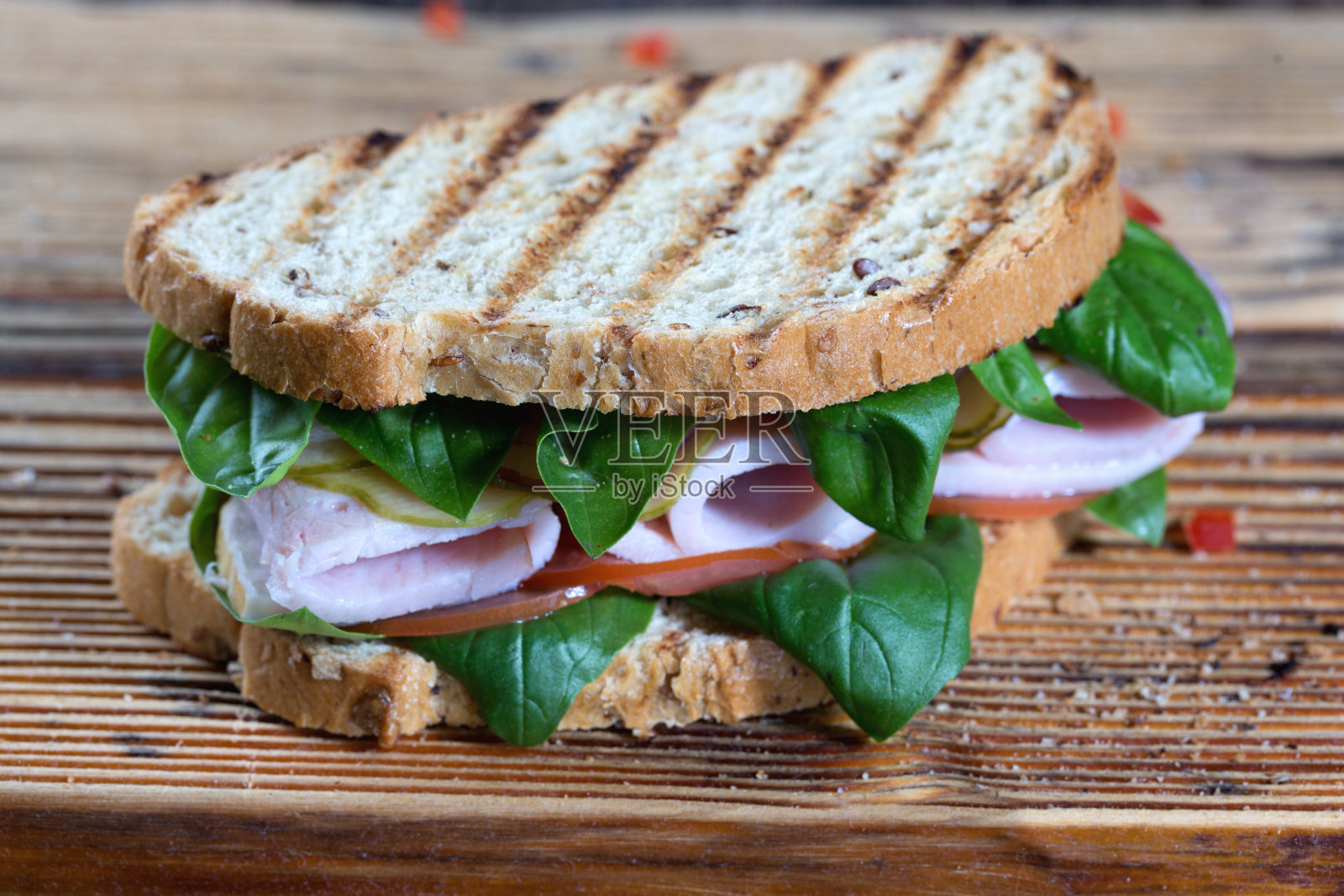 美味的火腿和香草三明治，以谷物面包为基础。照片摄影图片