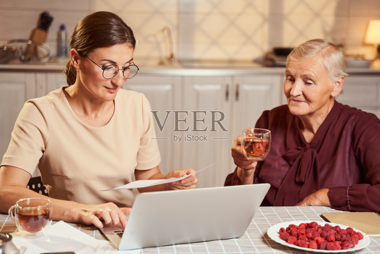 一名官方女性正在阅读报纸，并在笔记本电脑上输入信息照片摄影图片