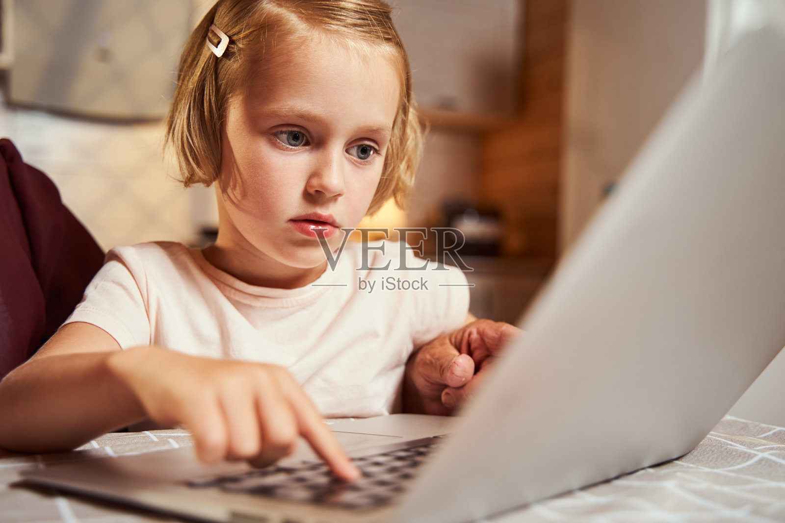 专注的孩子按下笔记本电脑键盘上的一个按钮照片摄影图片