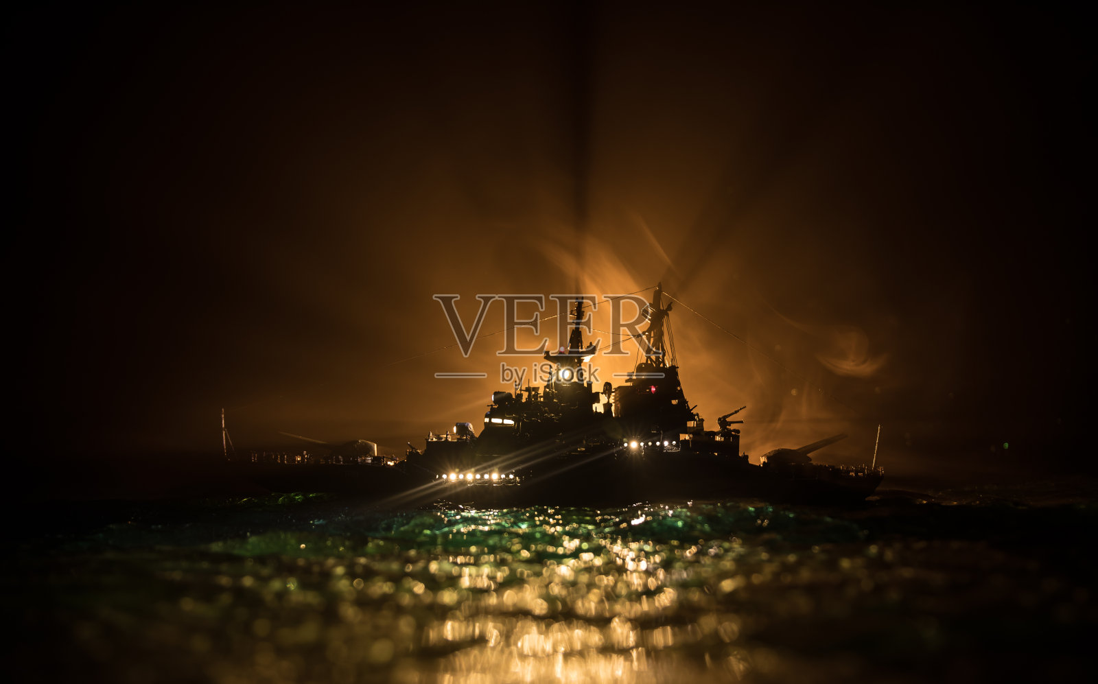 在雾蒙蒙的背景中，一群人站在模糊的军用战舰前的剪影。有选择性的重点。照片摄影图片