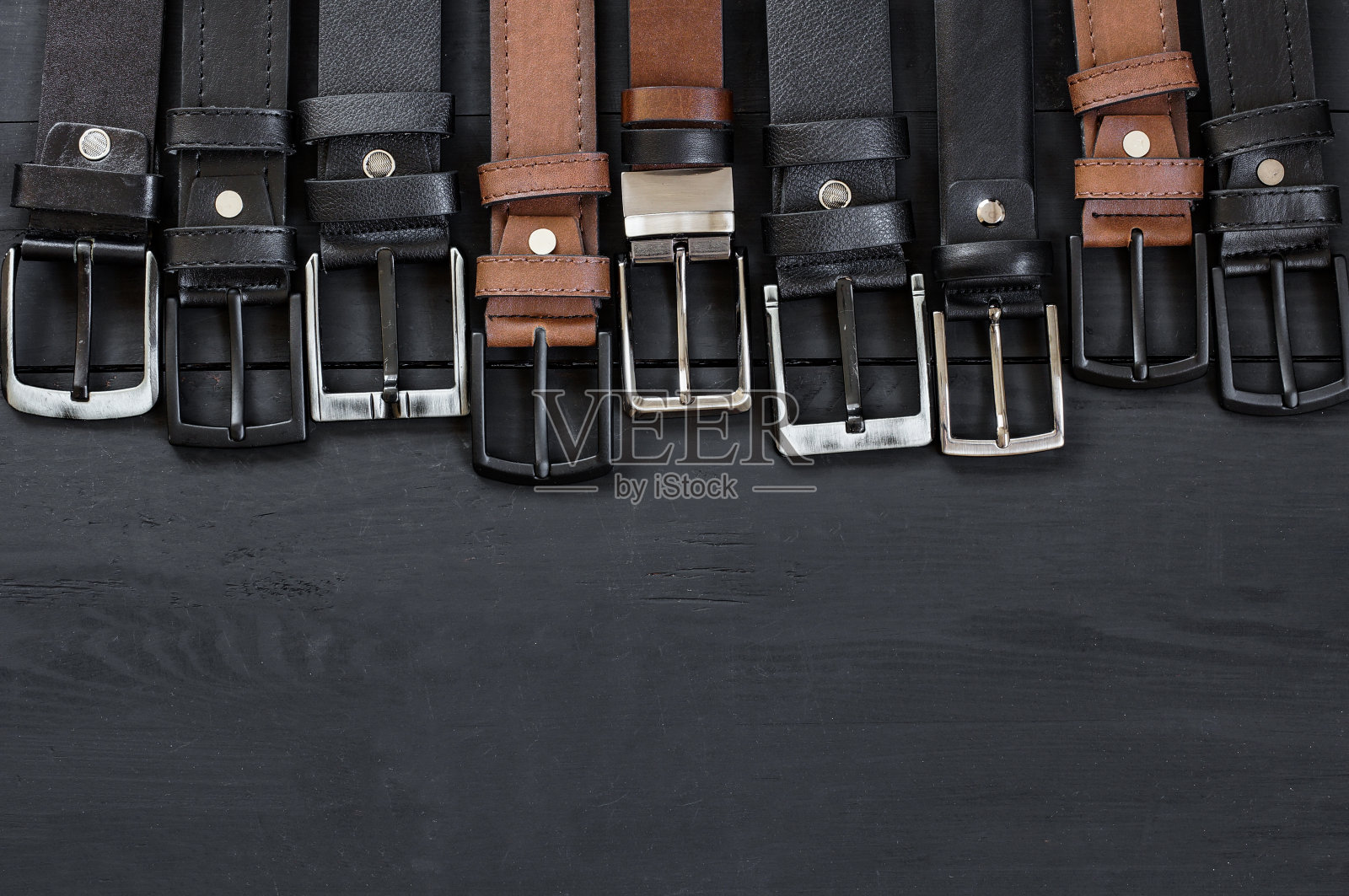 真皮和人造皮带的概念，棕色和黑色皮革牛仔布，亚麻或灯芯绒裤子，时尚的皮带照片摄影图片