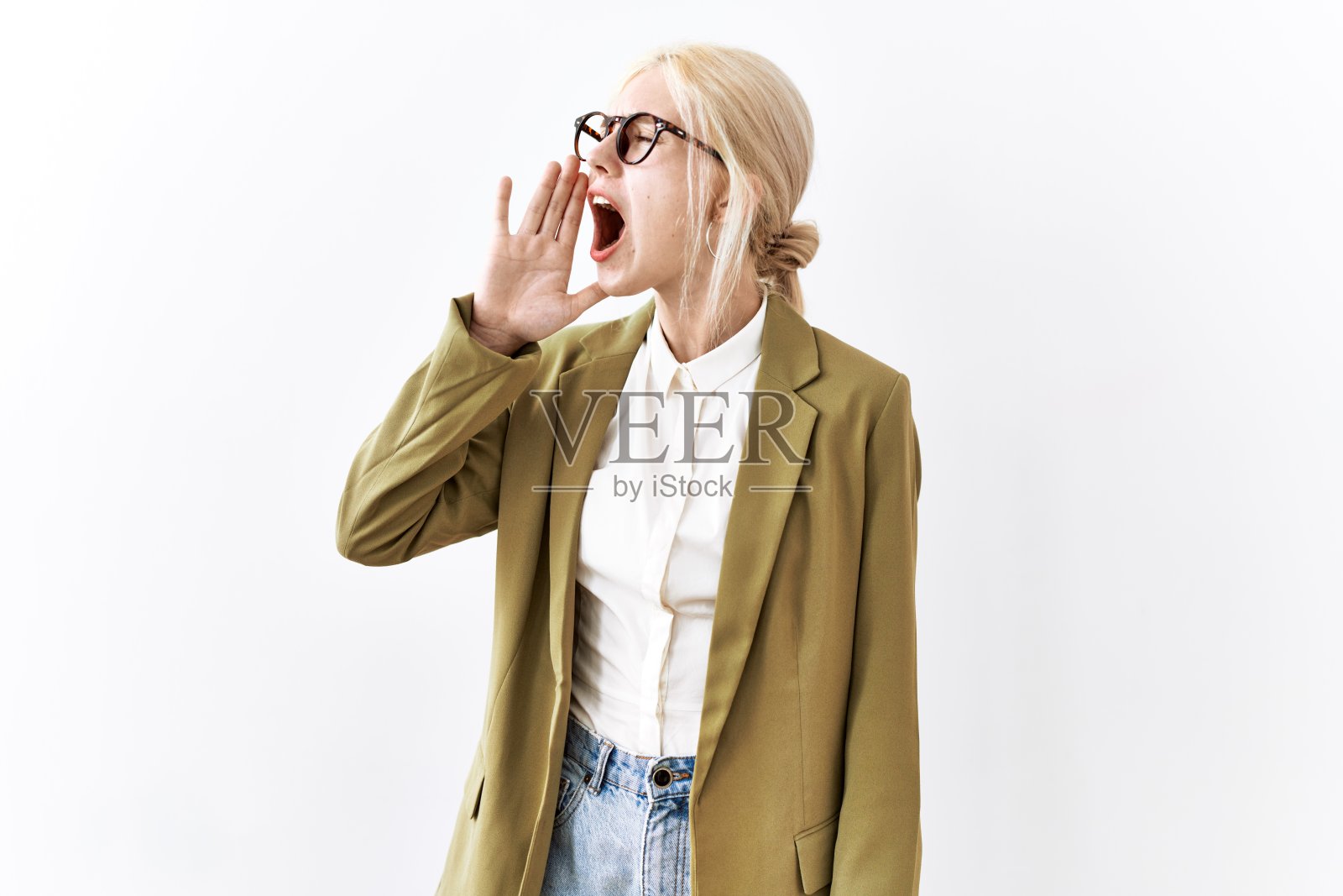 漂亮的白人女商人站在孤立的背景下大声尖叫，用手捂住嘴。通信的概念。照片摄影图片