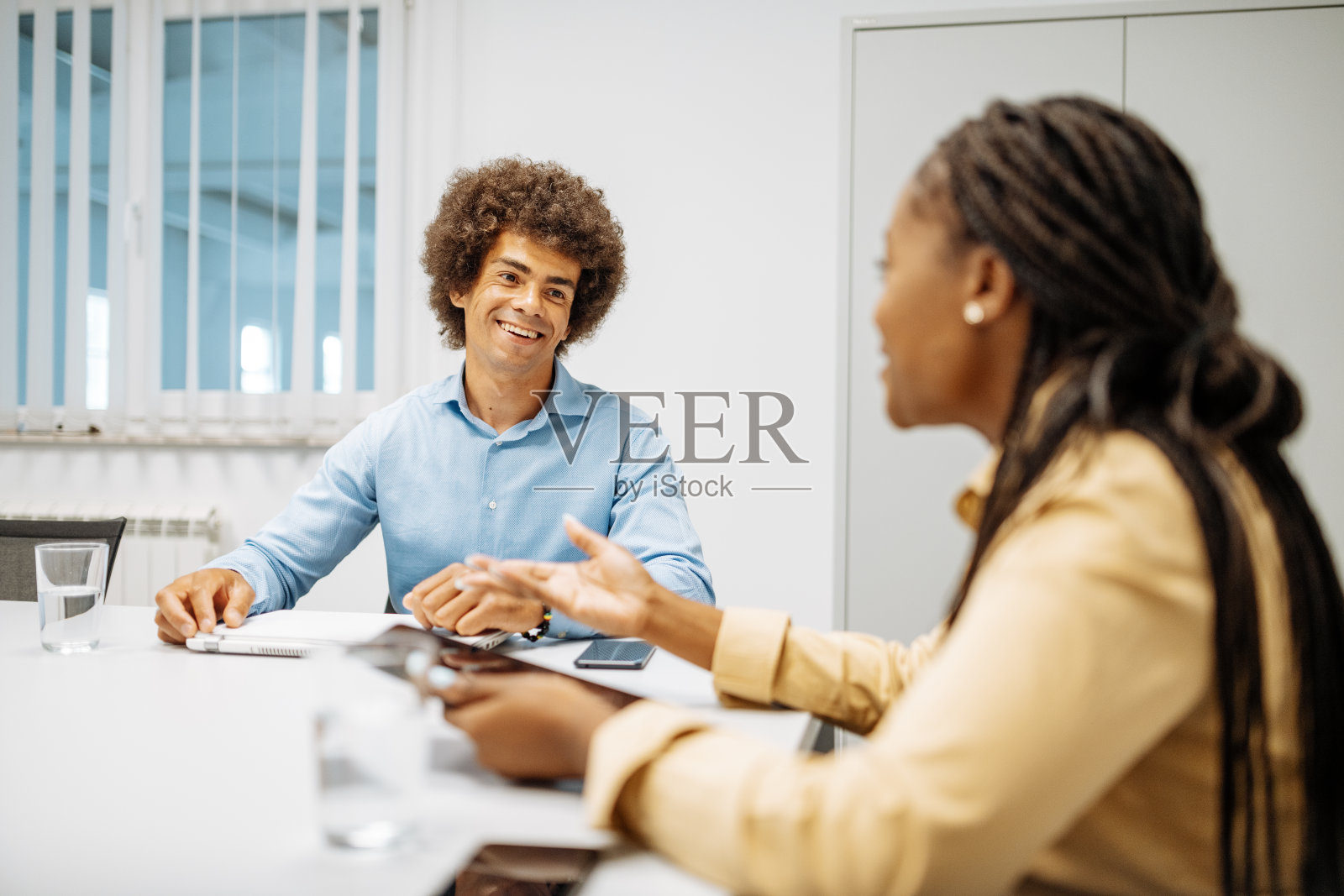 欢声笑语的多元同事们在办公室里谈天说地——重新开业后的商务会议照片摄影图片