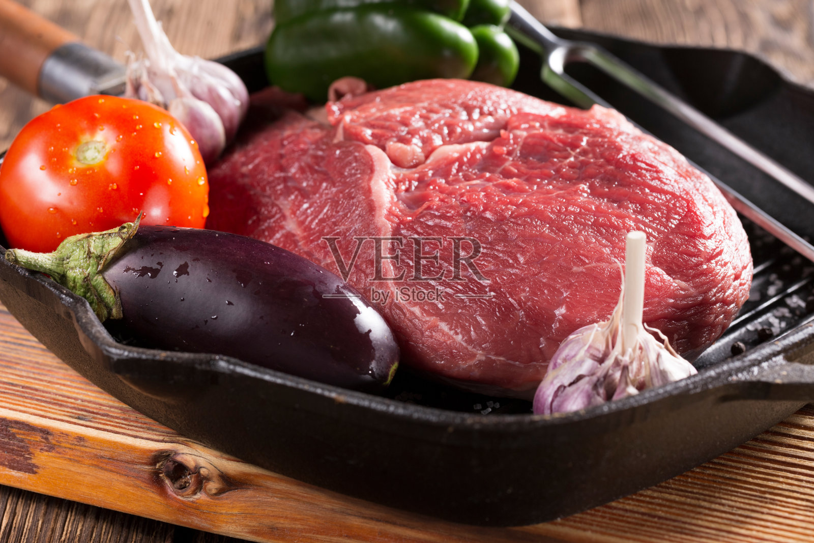 在铸铁平底锅中烤的一块肉和蔬菜照片摄影图片