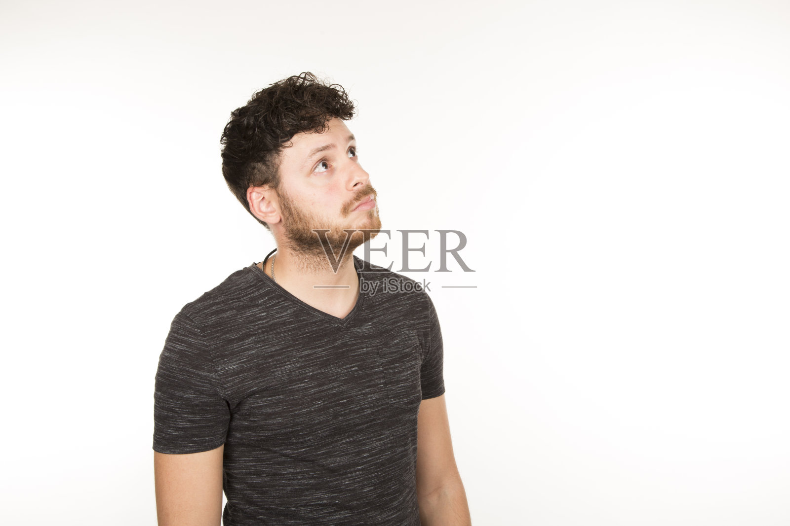 白人年轻男子，深色头发，留着胡子，侧身看照片摄影图片