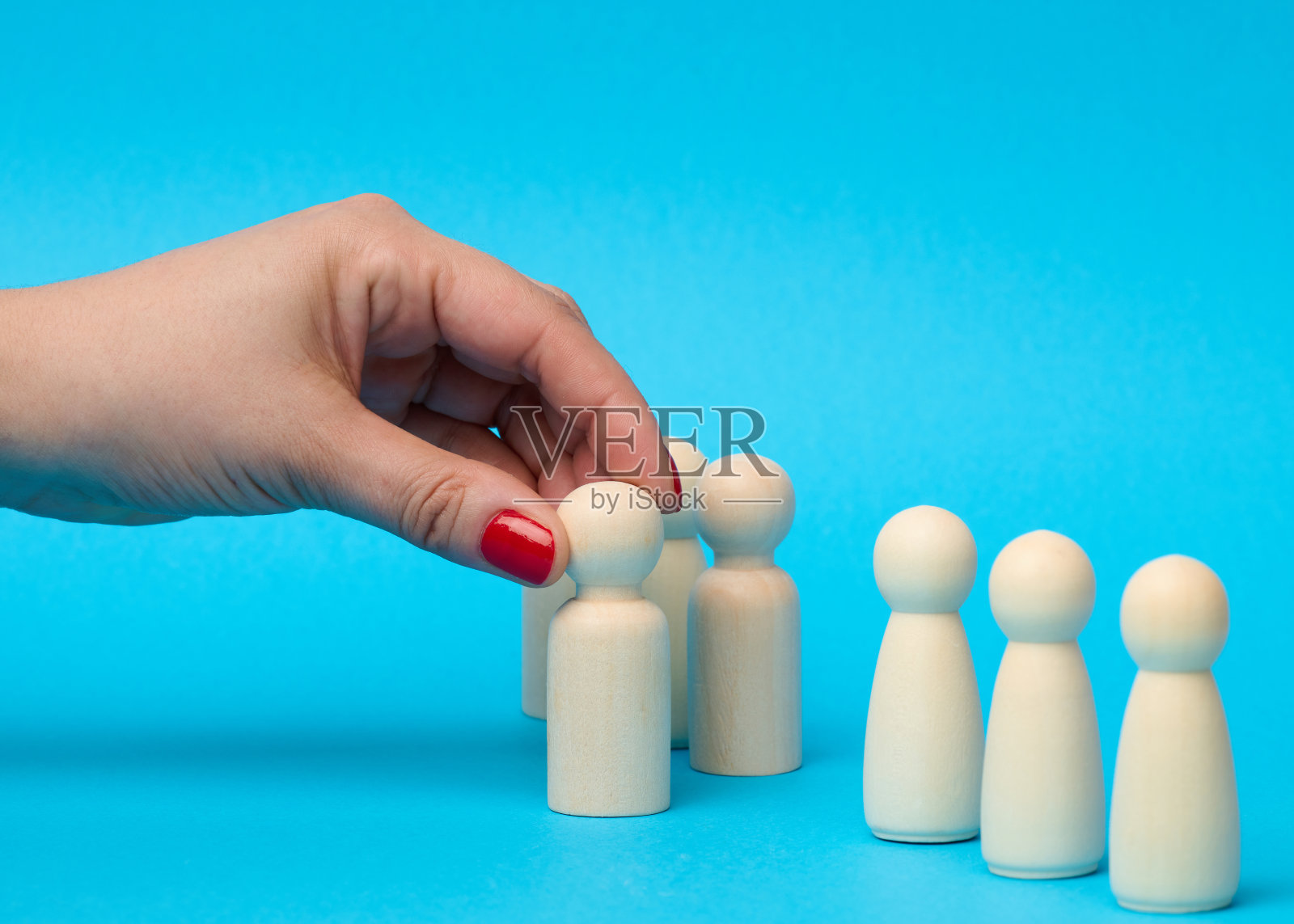 从人群中选出一个木制的小雕像。寻找优秀员工的理念照片摄影图片