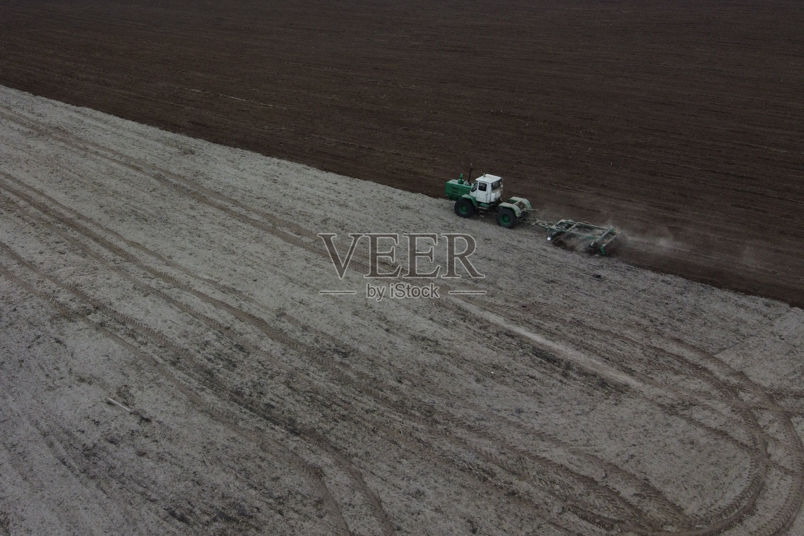 拖拉机犁地，鸟瞰图。农业景观。照片摄影图片