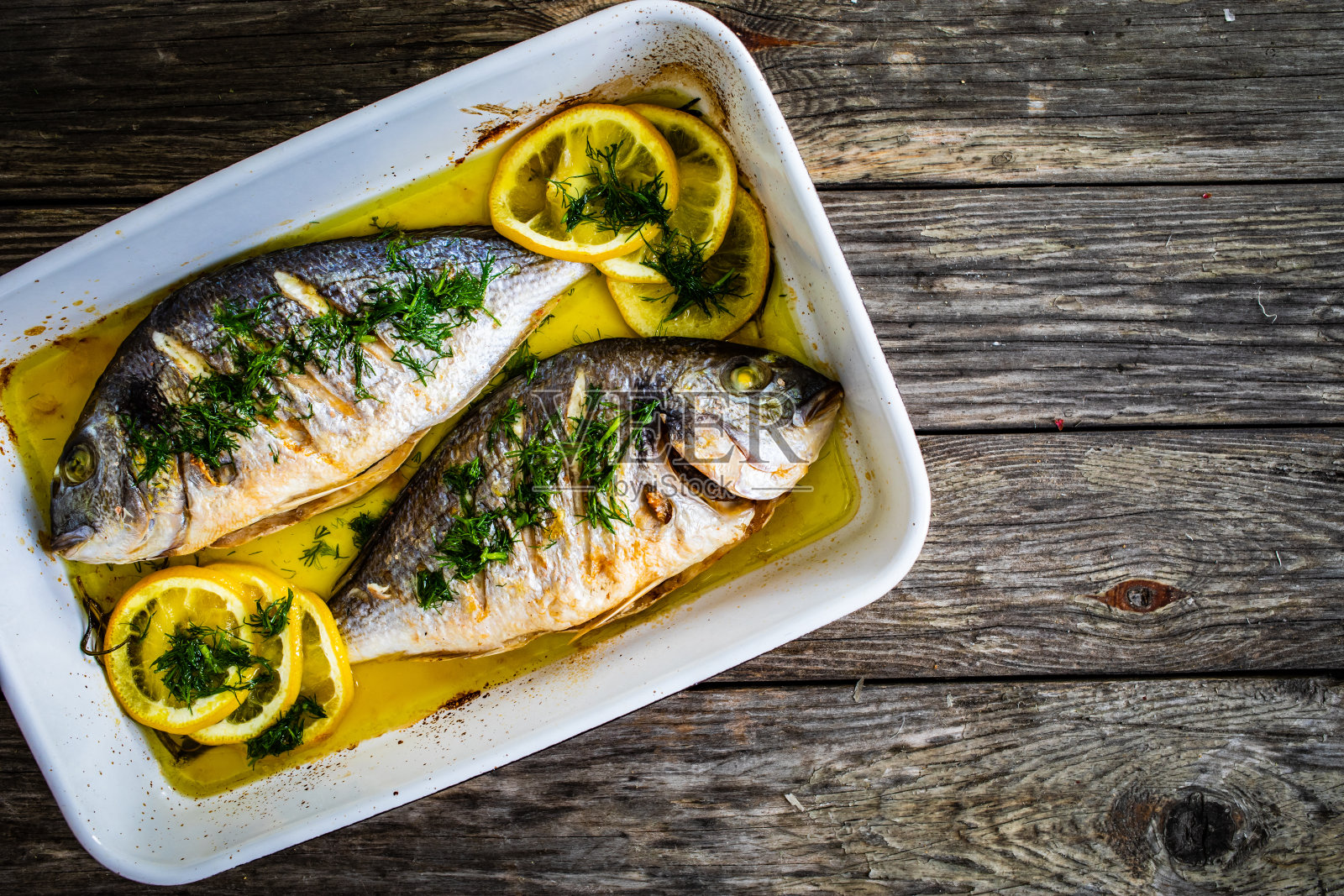 鱼碟——用平底锅盛有蔬菜的烤海鲷照片摄影图片