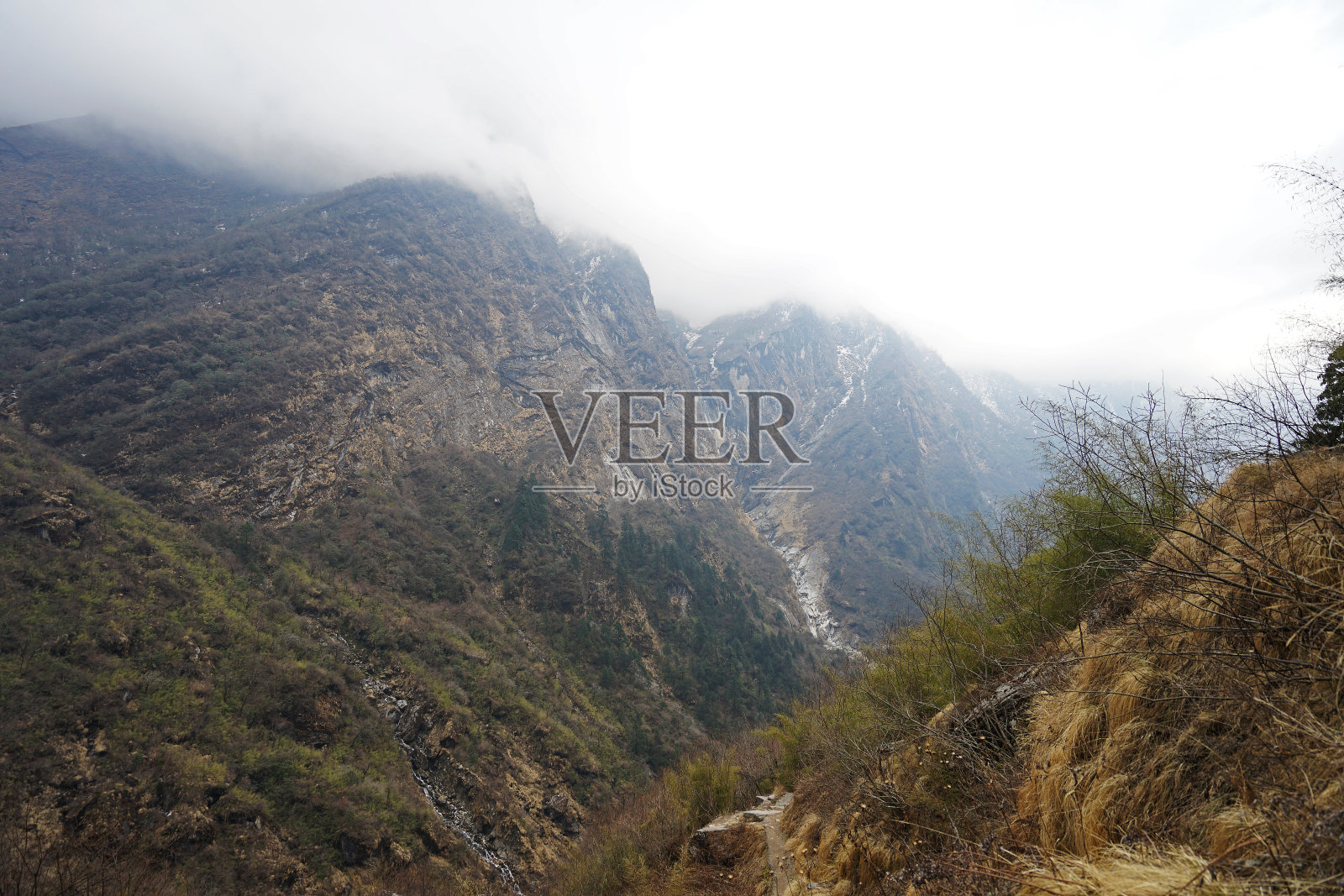 自然溪流之间的雪和岩石悬崖与蓝天照片摄影图片