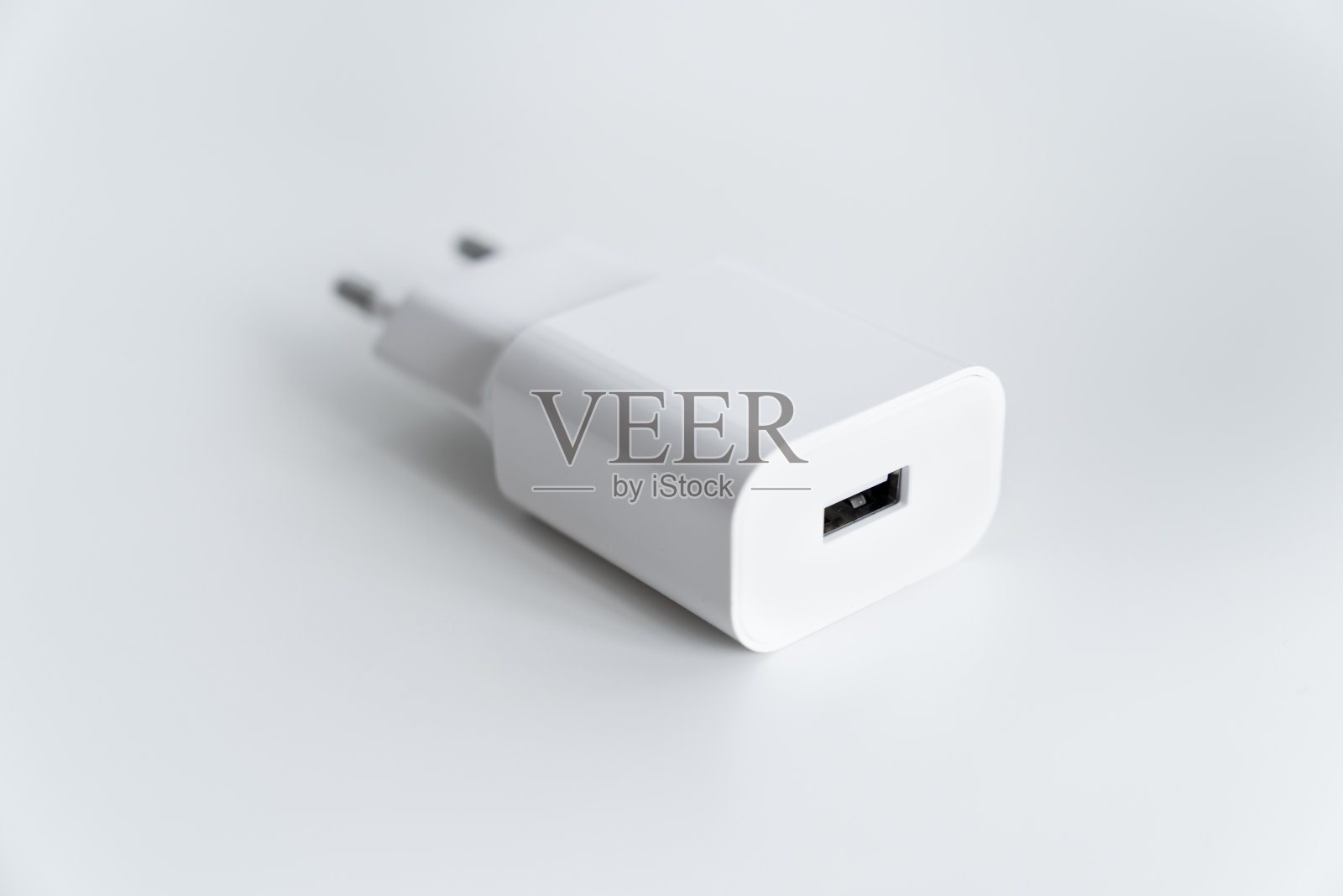 带有USB接口的交流充电器，适用于智能手机或平板电脑，背景为白色。照片摄影图片