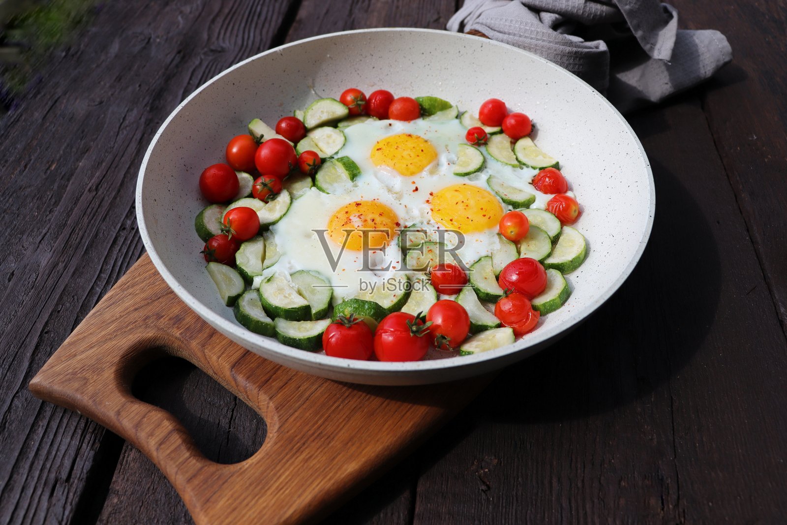 晚早餐，西葫芦煎蛋，樱桃番茄。沙克舒卡在煎锅里，背景是乡村。阿拉伯菜。犹太食品。照片摄影图片