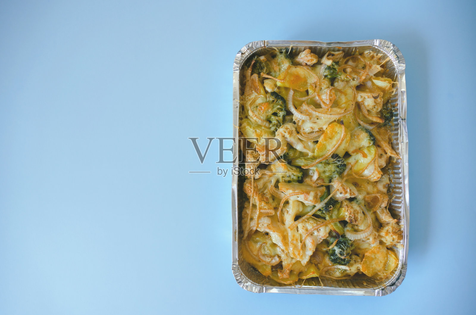 俯瞰素食蔬菜砂锅与土豆，花椰菜，洋葱，花椰菜绿色关闭。烤宽面条。在烤箱里烤土豆。健康的自制素食照片摄影图片