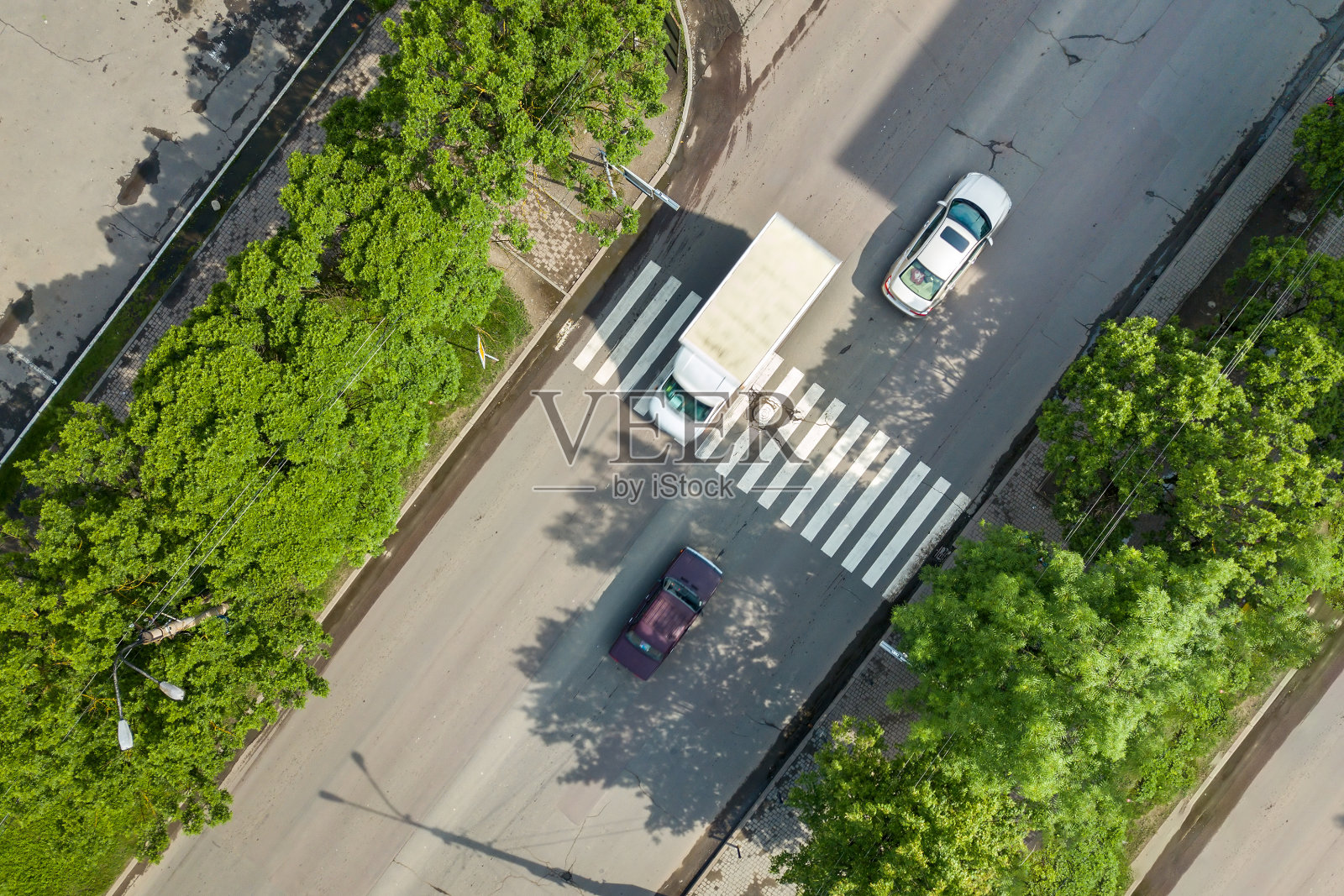从上往下鸟瞰图，繁忙的街道与移动的汽车交通和斑马线人行横道。照片摄影图片