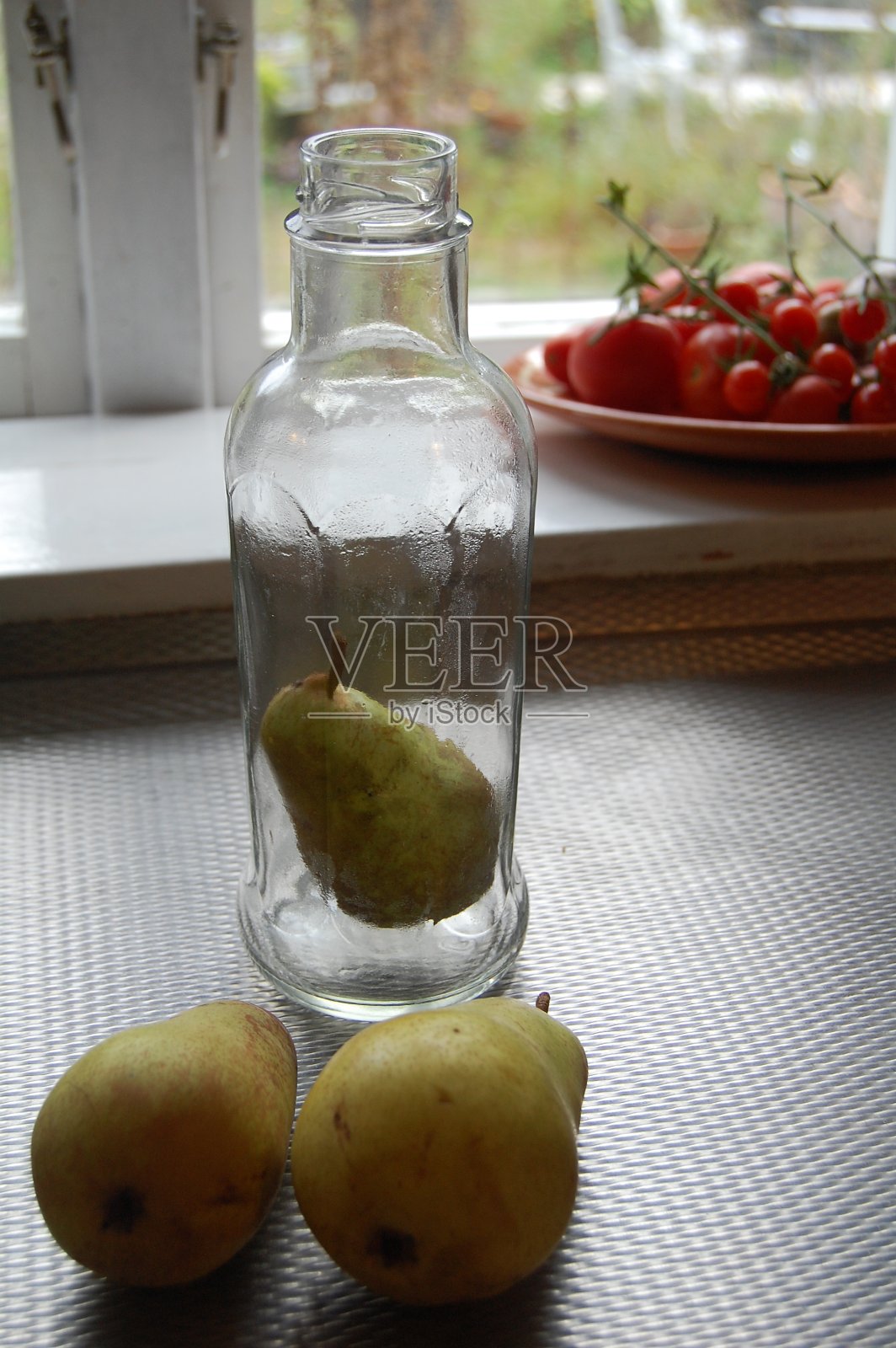 瓶子里的梨。照片摄影图片