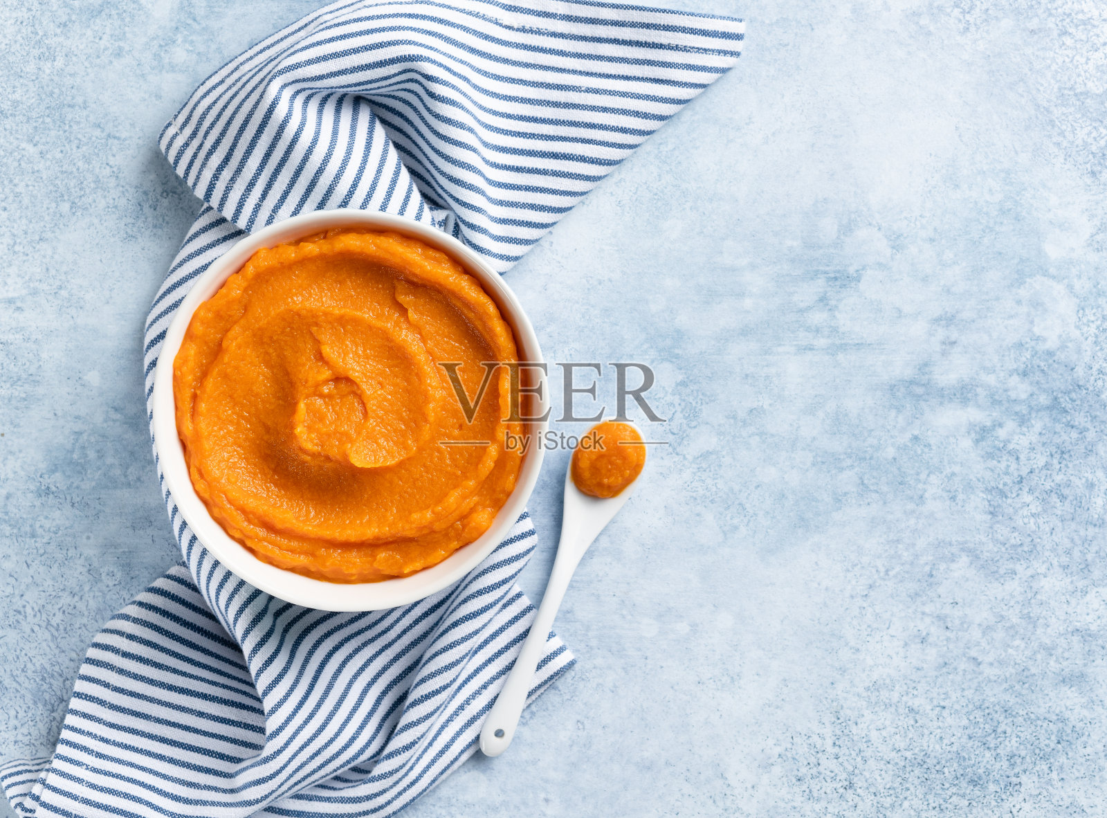 南瓜泥(捣碎的冬南瓜)放在白色的陶瓷碗里俯视图。副本的空间。季节性烹饪概念。照片摄影图片