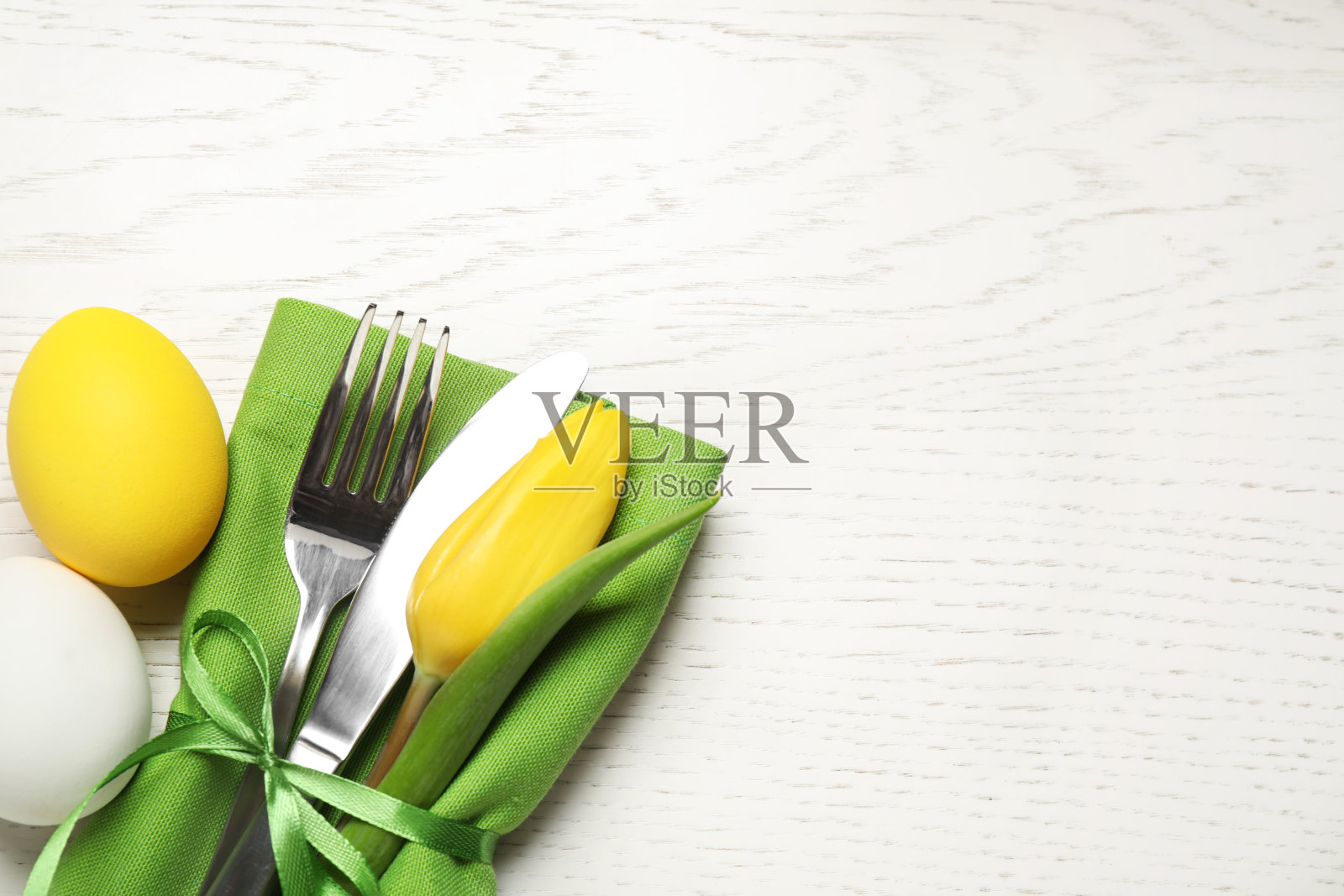 餐具和鸡蛋放在白色的木桌上，平放有文字空间。复活节庆祝活动照片摄影图片