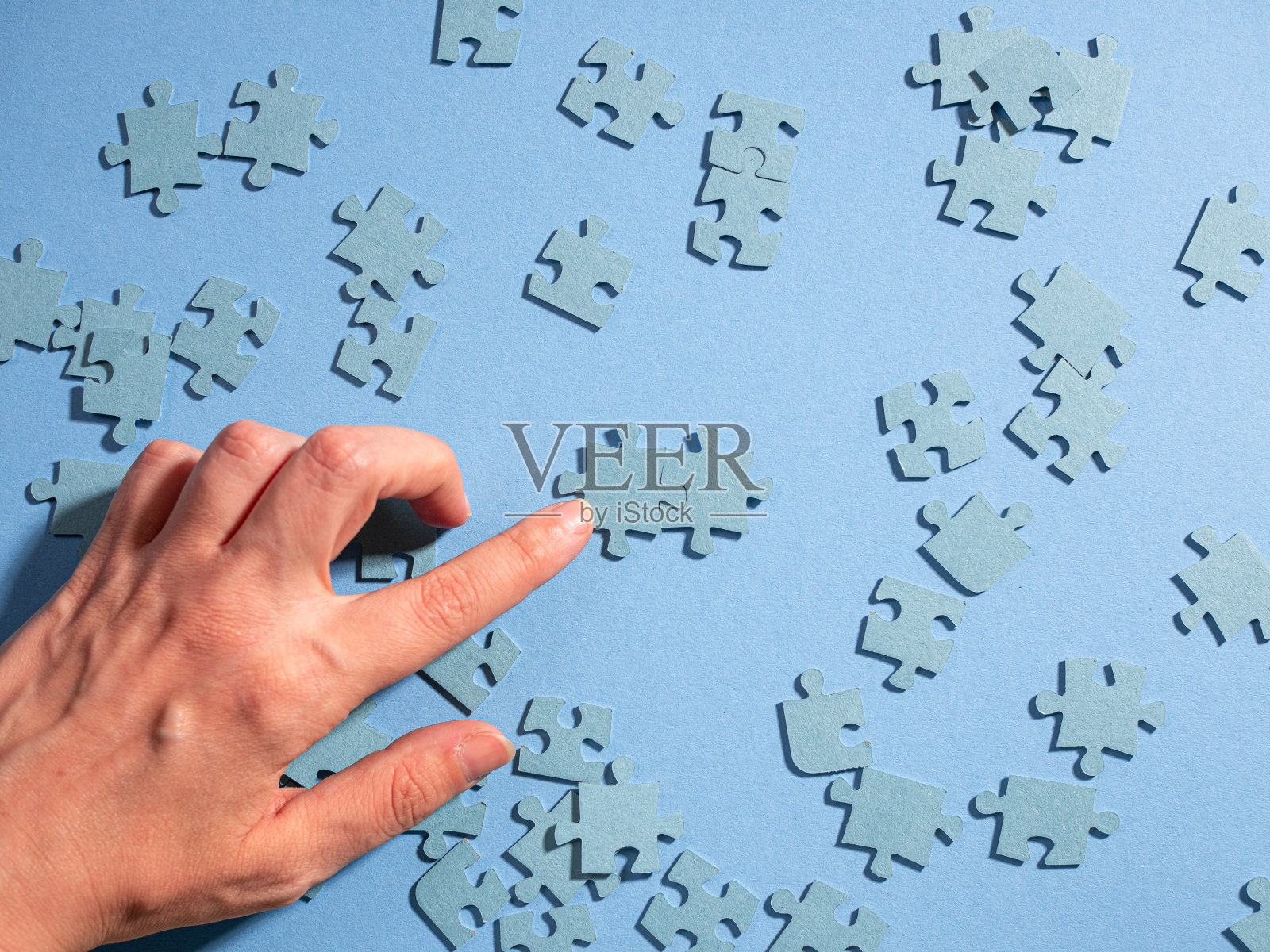 一个人的手组装了一对拼图，两种元素照片摄影图片