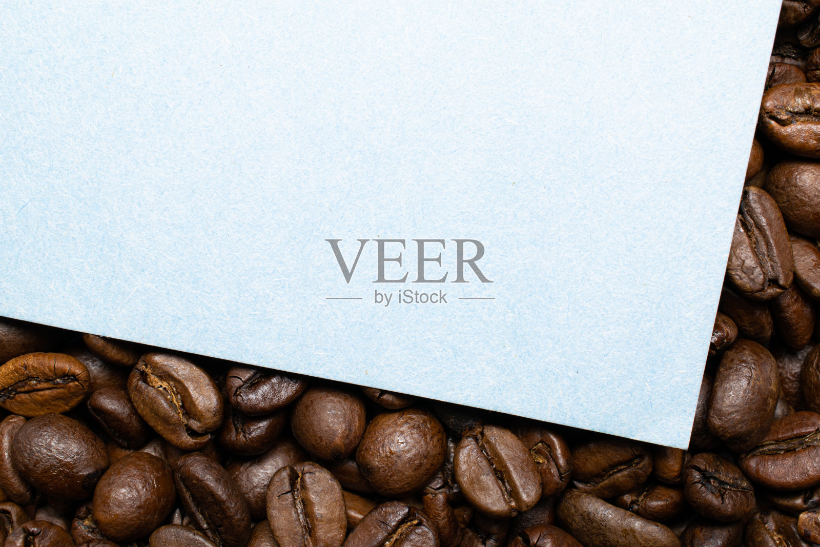 白纸的背景是咖啡豆。为您的文本添加标签。照片摄影图片