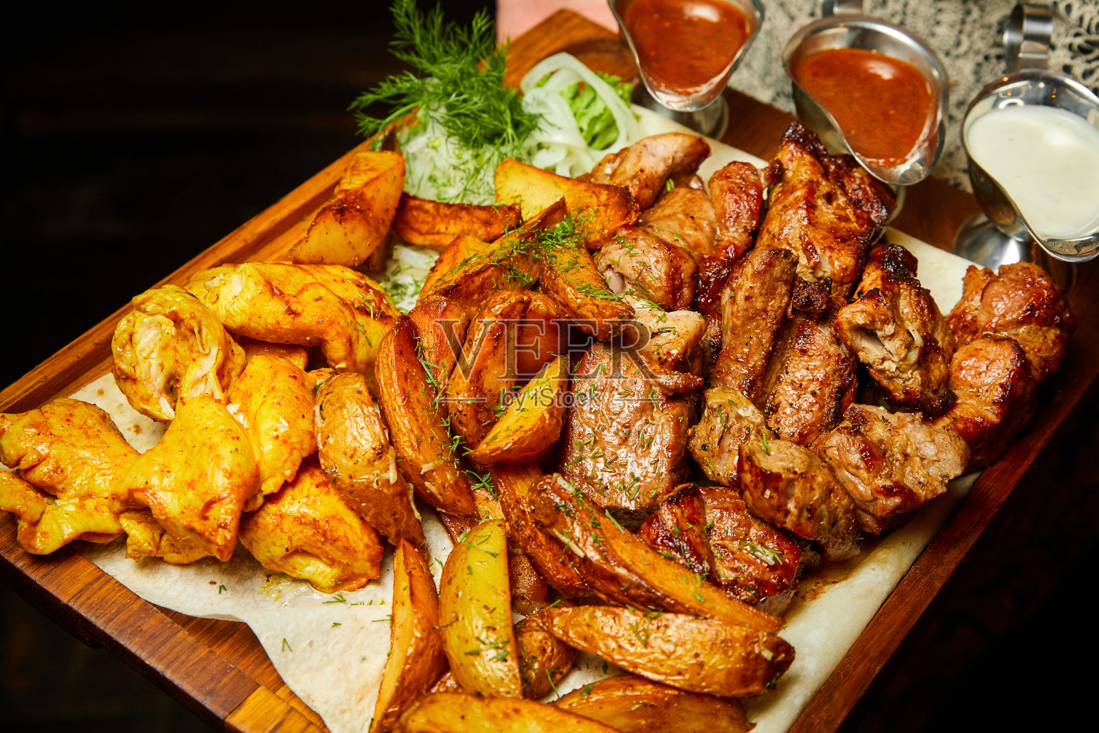 烤土豆和烤蔬菜与烤肉串和香肠。特写,有选择性的重点照片摄影图片
