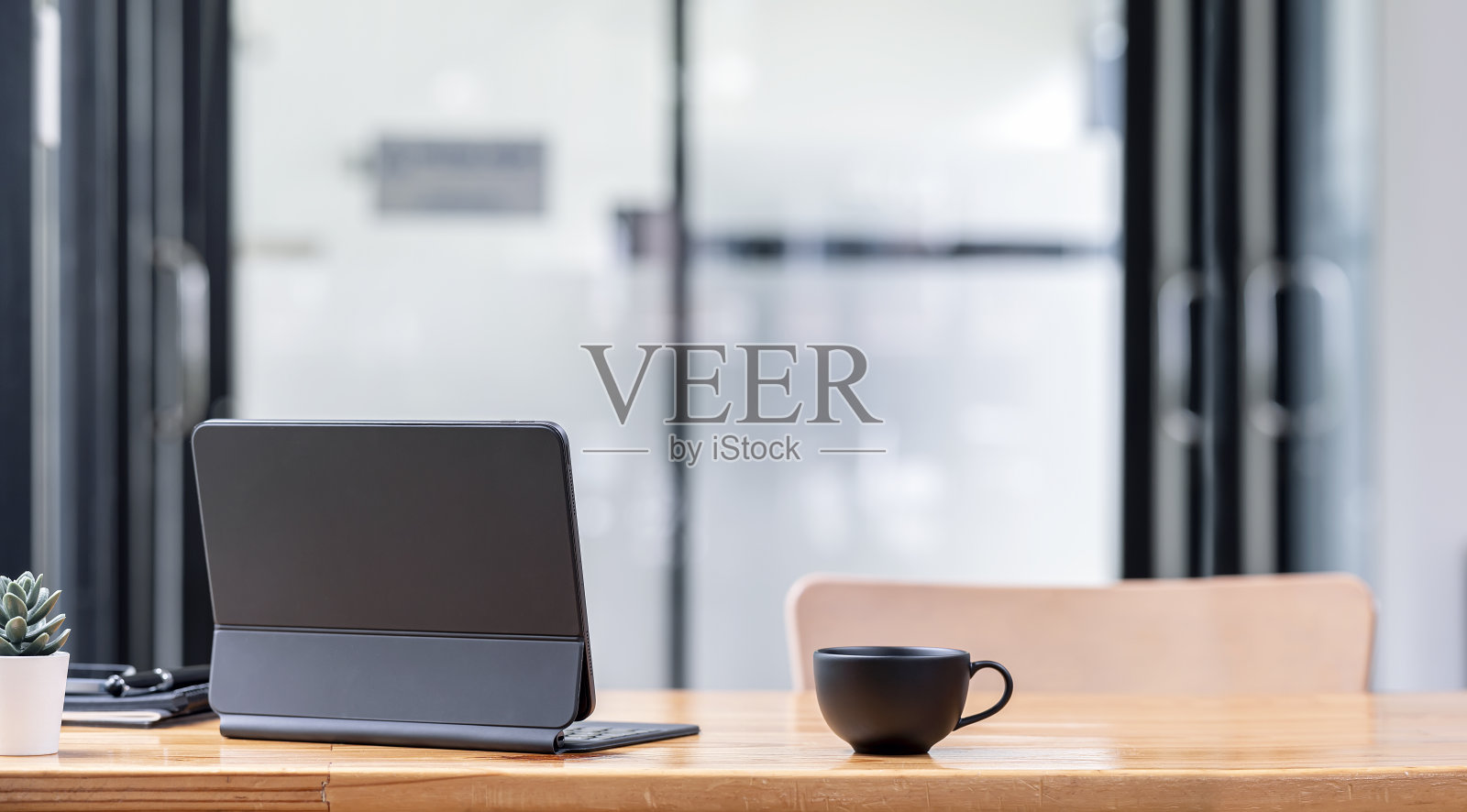 背面的平板电脑与魔术键盘和一杯咖啡在木桌。照片摄影图片