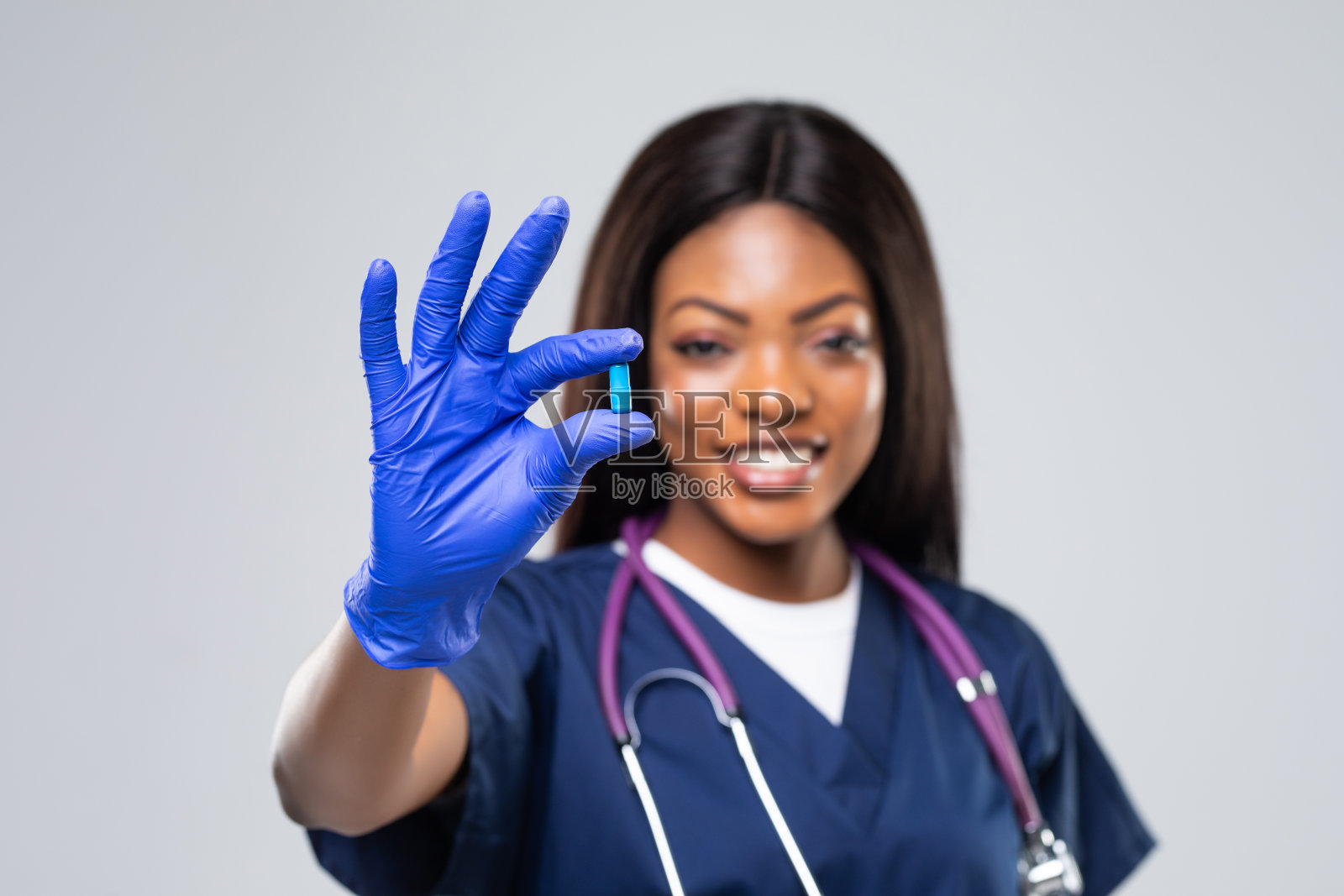 微笑的非裔美国女医生与药丸和听诊器背景照片摄影图片